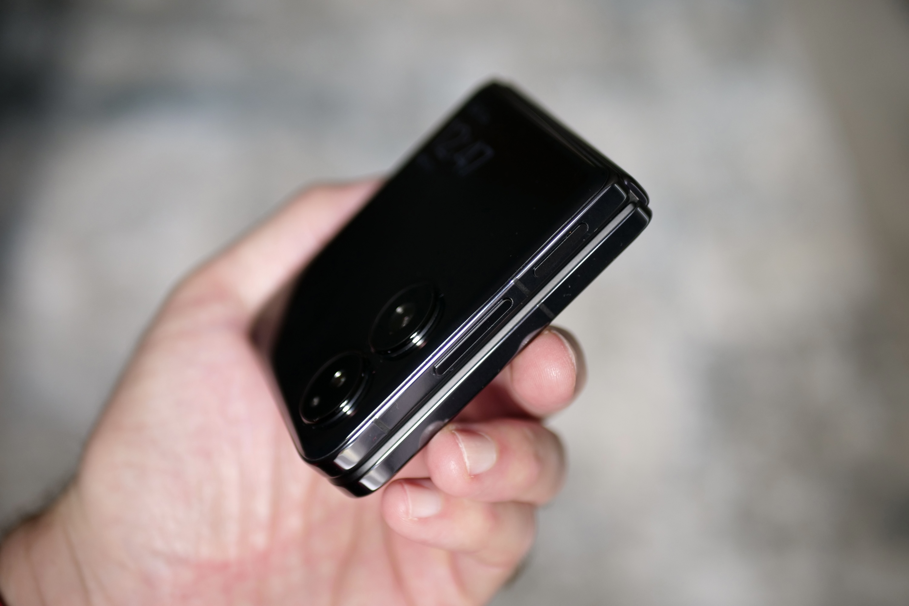 A person holding the Xiaomi Mix Flip, seen from the side.