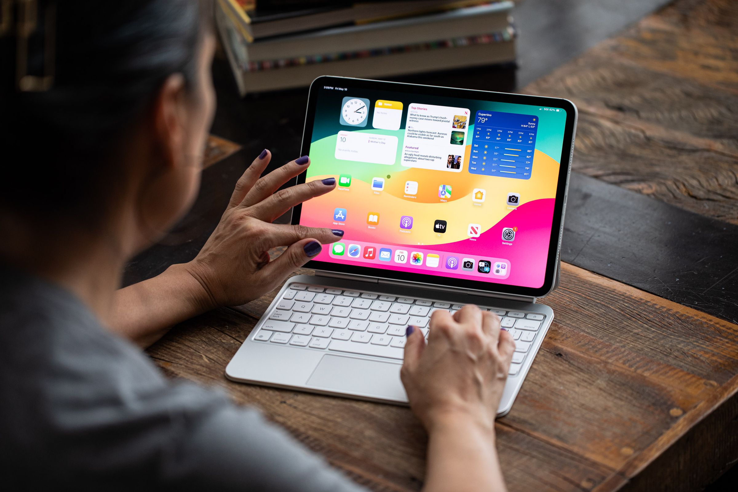 A photo of a person pinching the screen on an iPad Pro.