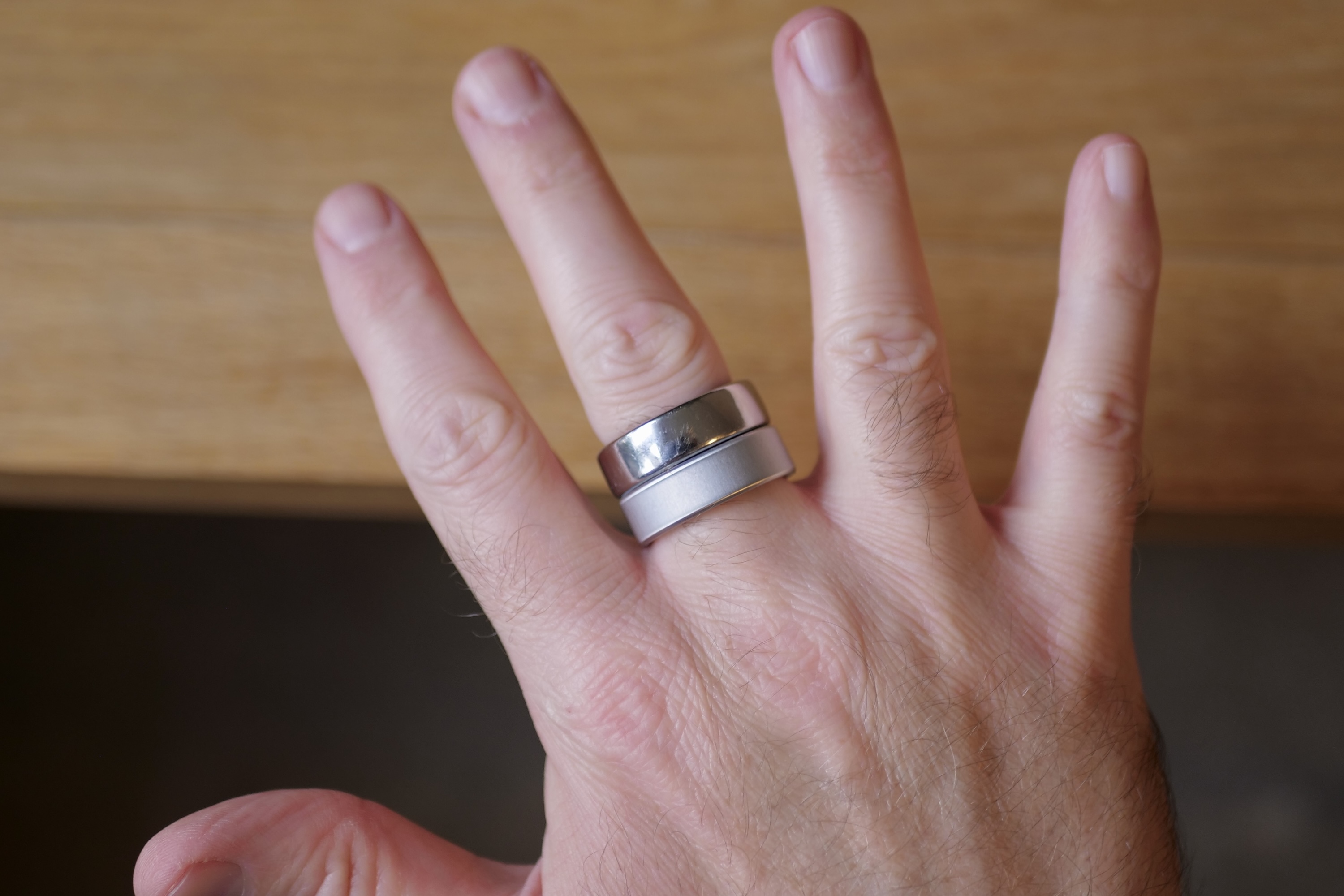 A person wearing the Oura Ring 3 and Oura Ring 4.