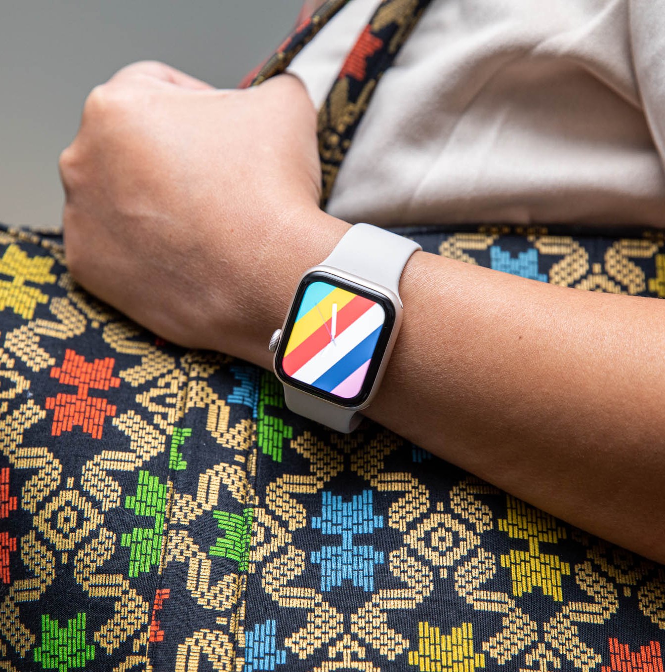 Woman holding a purse while modeling the Stripes watchface on the Apple Watch SE (2022)