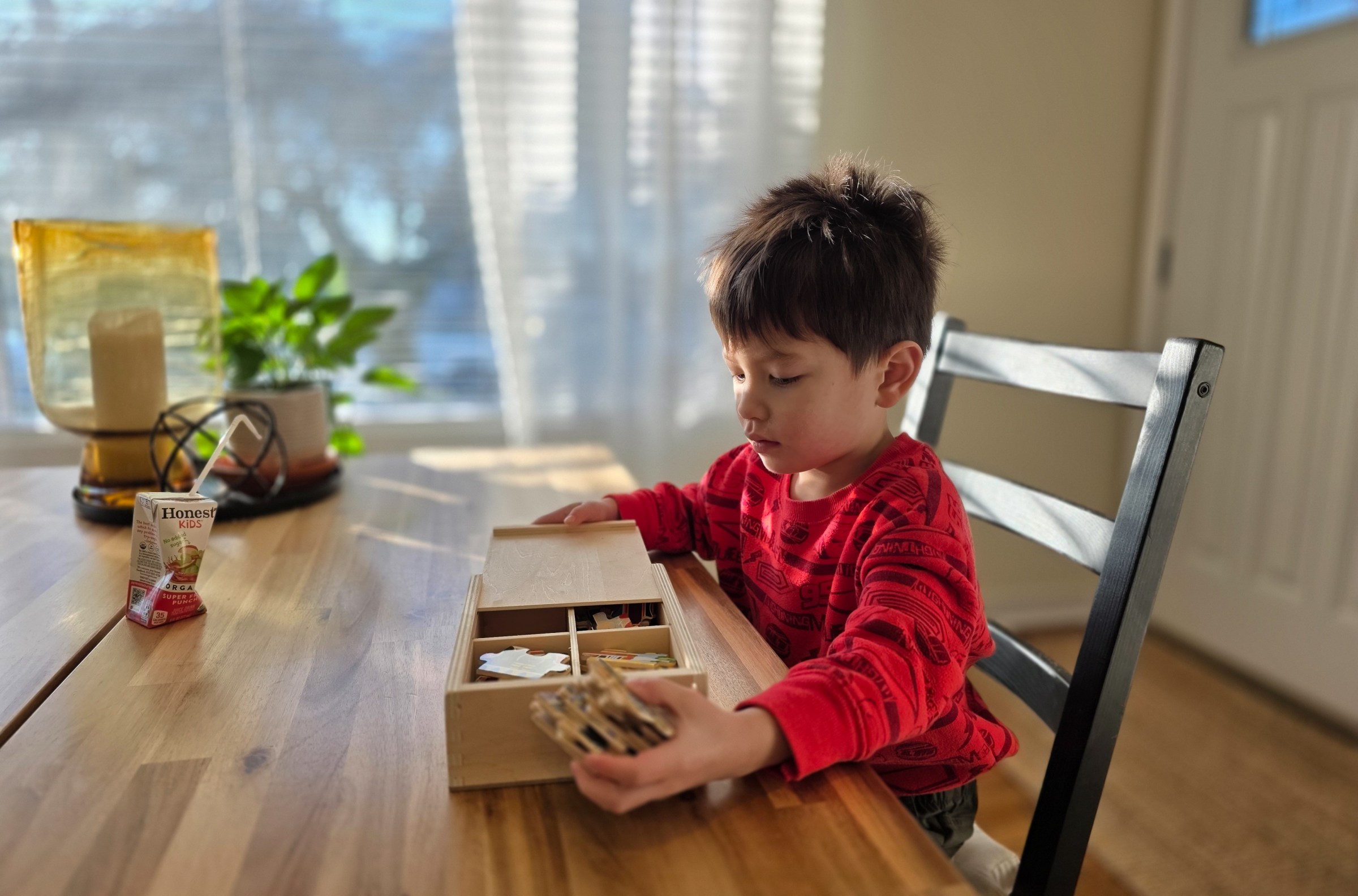 Child sitting at a table playing with a puzzle.