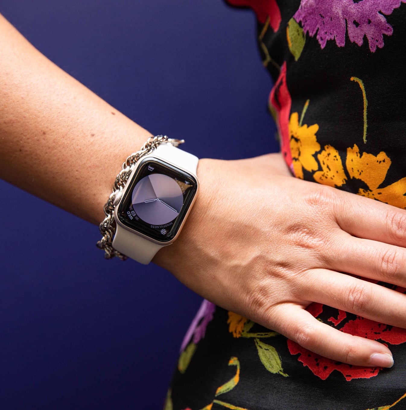 Woman in floral dress with hand on hip modeling Apple watch SE (2022)