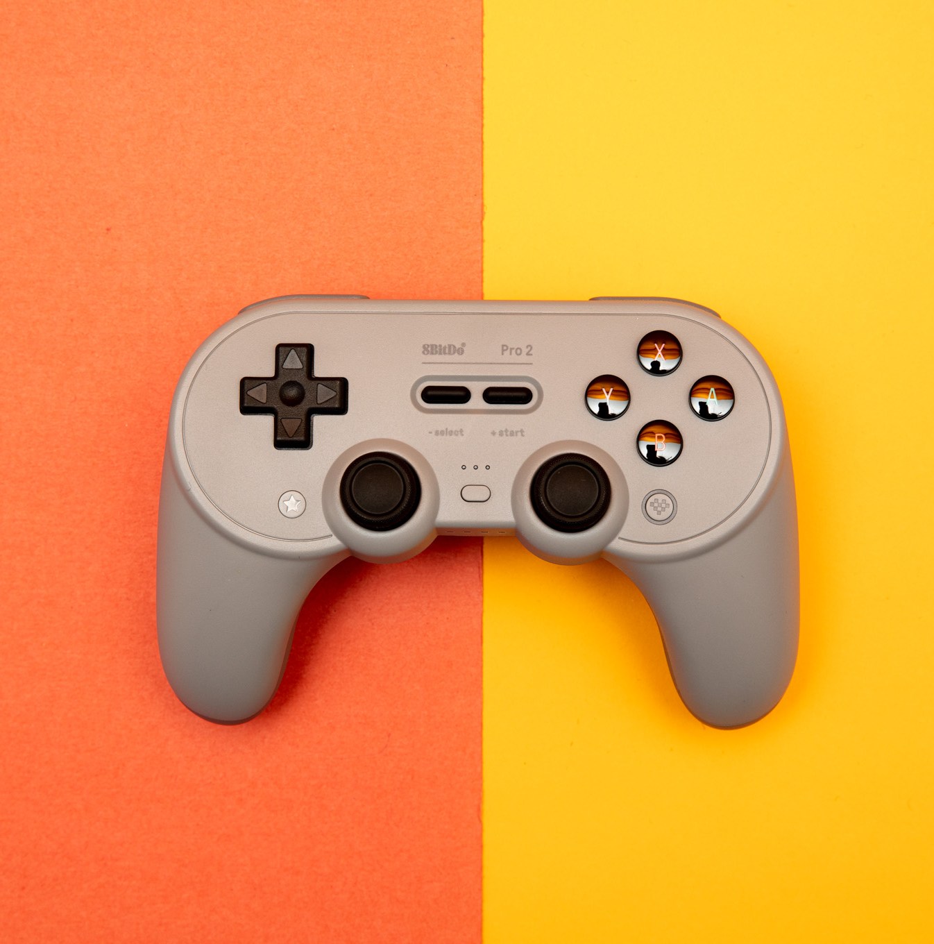 The 8BitDo Pro 2 wireless controller for the Nintendo Switch and other platforms sitting on a two-toned backdrop.