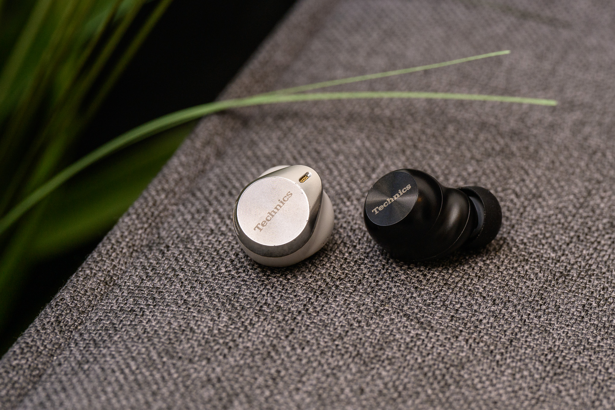 A side-by-side photo of the Technics AZ80 and AZ100 earbuds.