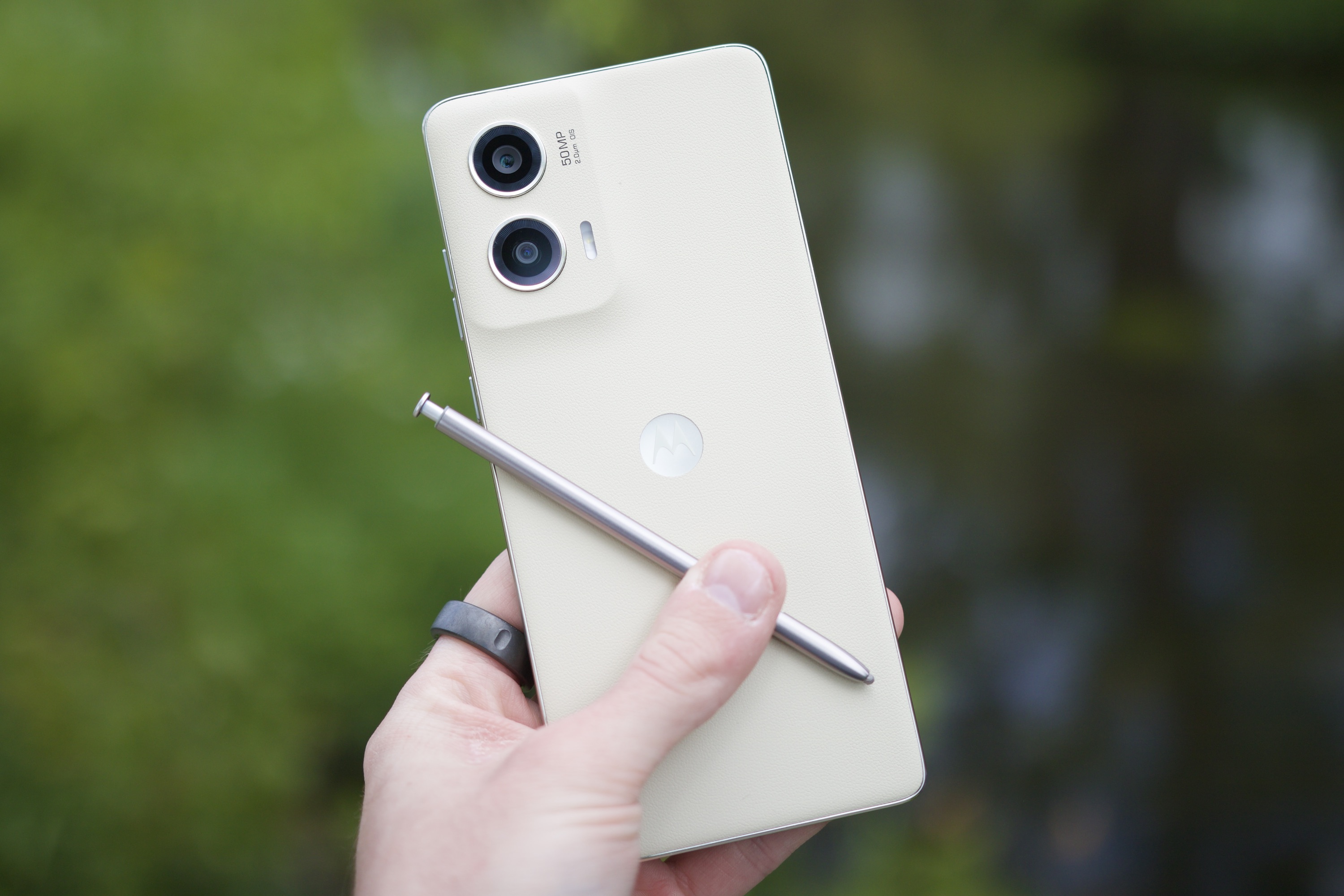 Someone holding the Moto G Stylus 5G (2024), showing the back of the phone and its stylus.