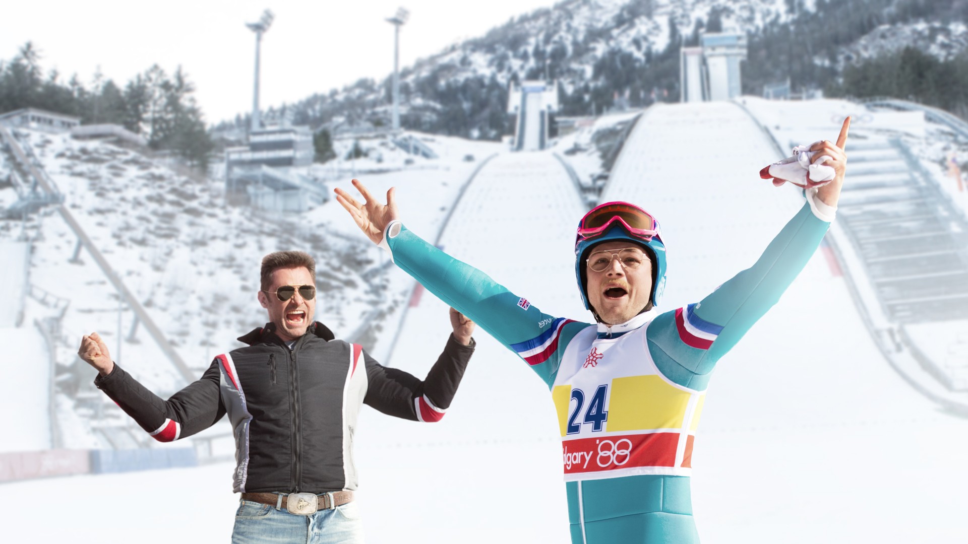 A skier celebrates with his coach outside in Eddie the Eagle.