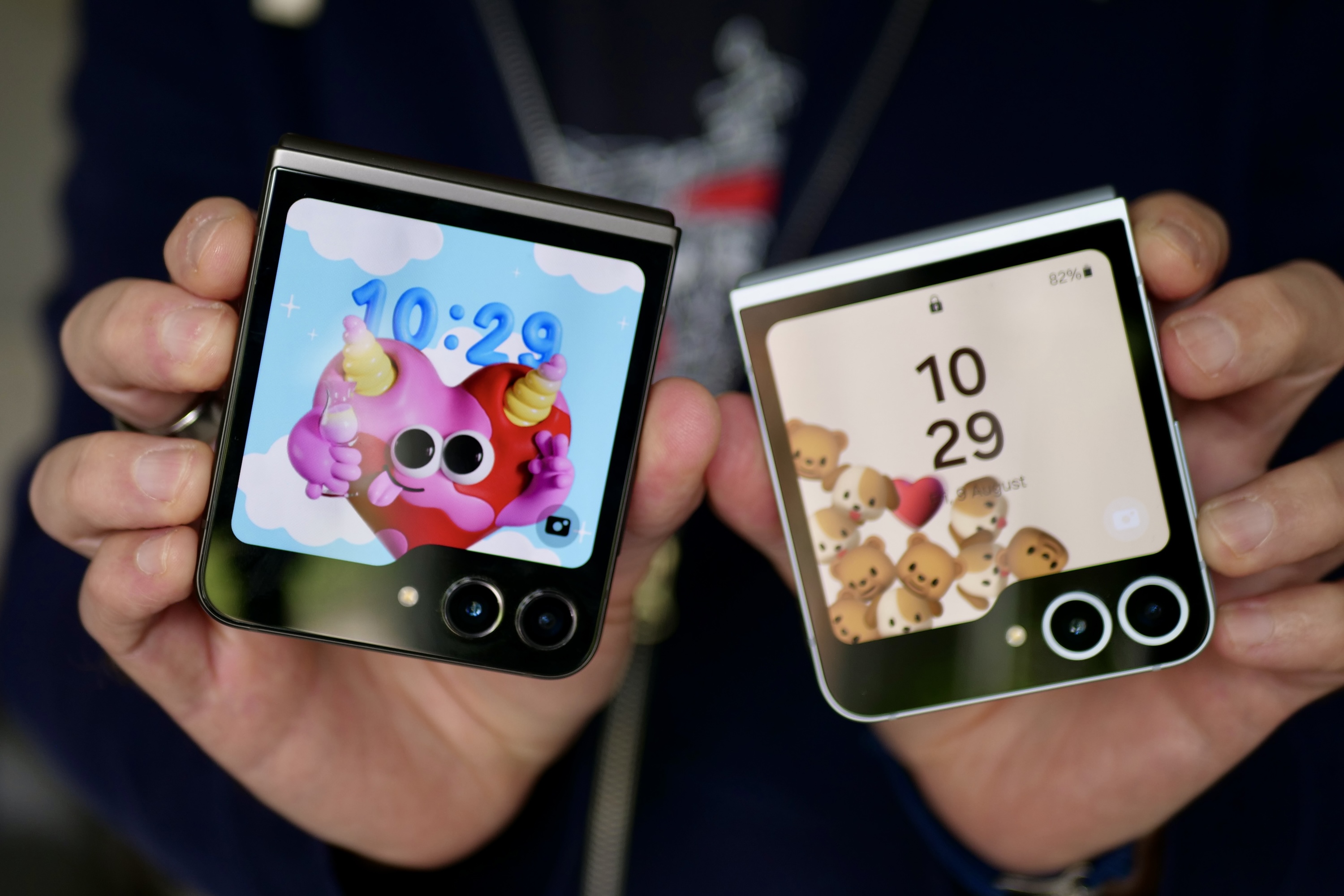 A person holding the Samsung Galaxy Z Flip 6 and Samsung Galaxy Z Flip 5 showing the cover screens.