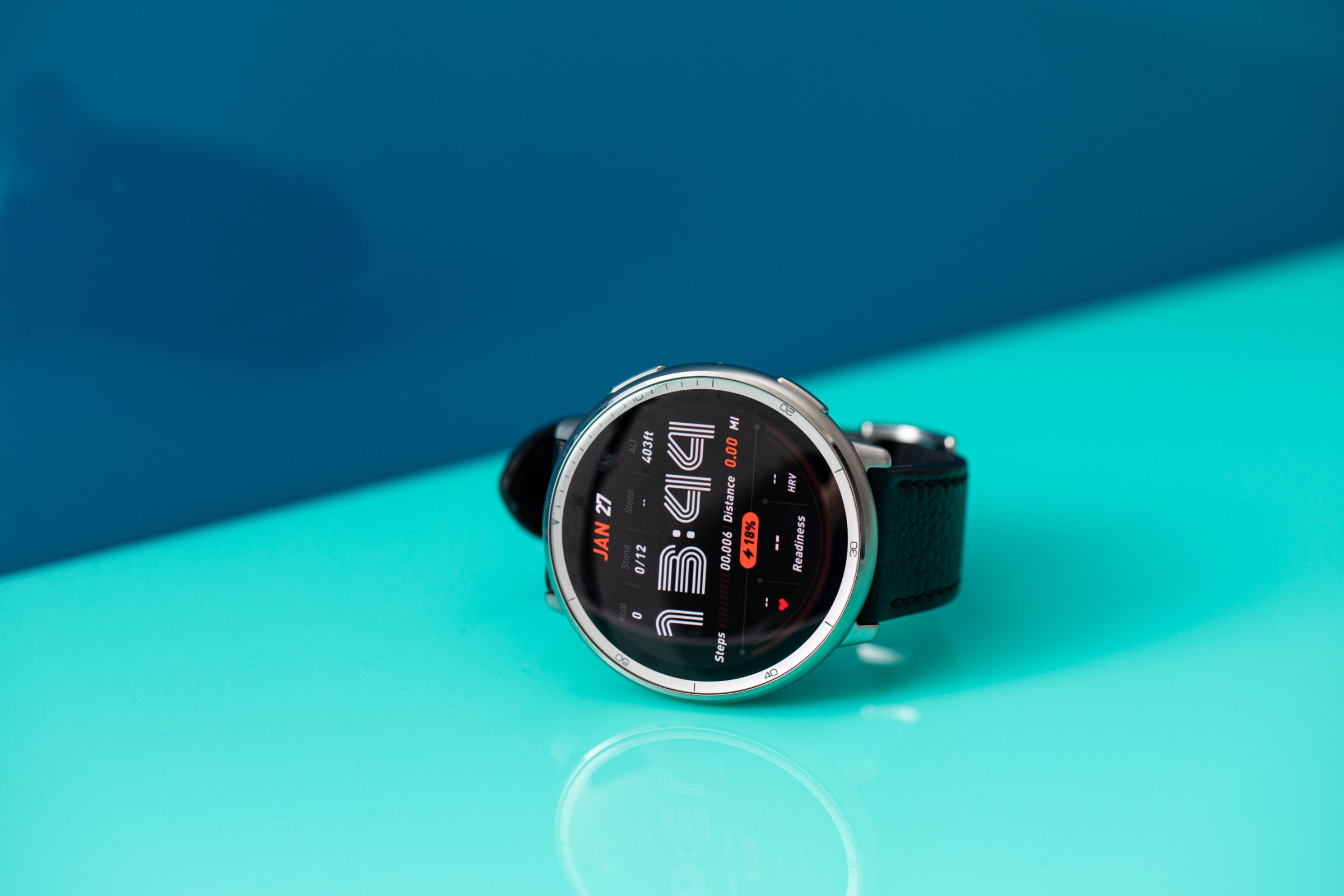Close up view of the Amazfit Active 2âs screen which shows a retro-styled watch face with a bright blue background behind the product.
