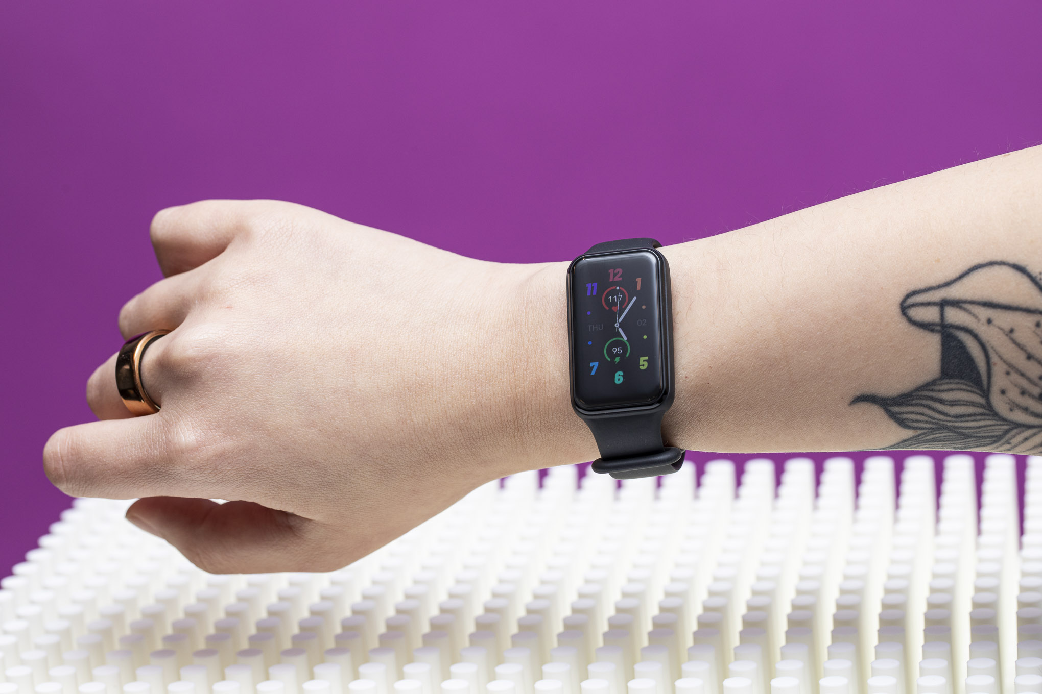 Amazfit Band 7 with colorful clock face worn on womanâs wrist.