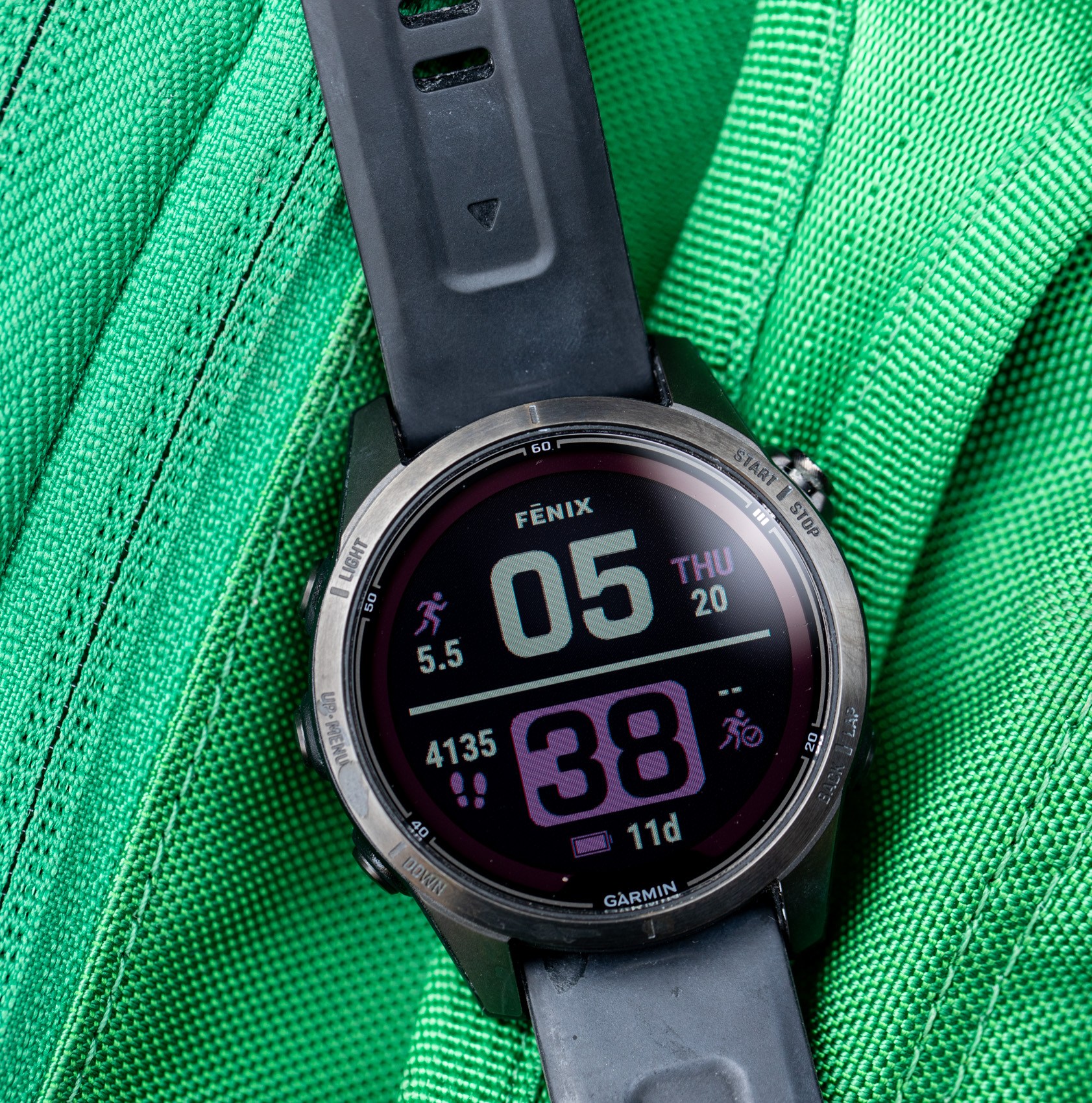 The Fenix 7S Pro on top of a green backpack