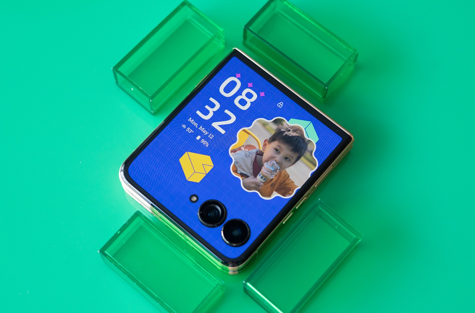 Motorola Razr Ultra on a green background showing cover screen