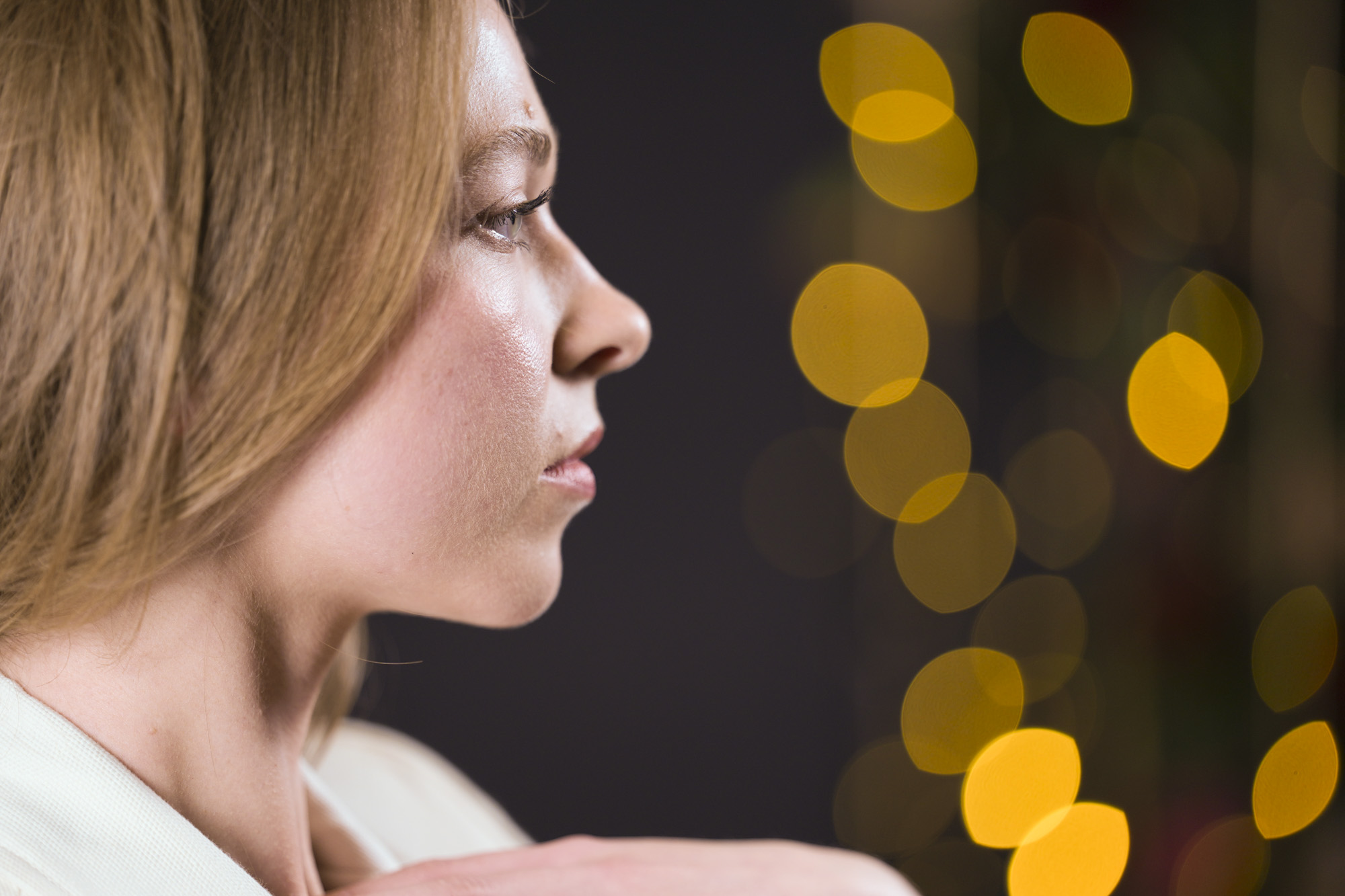 Portraits of a woman in smart jacket, in a studio with blurred fairy lights in background