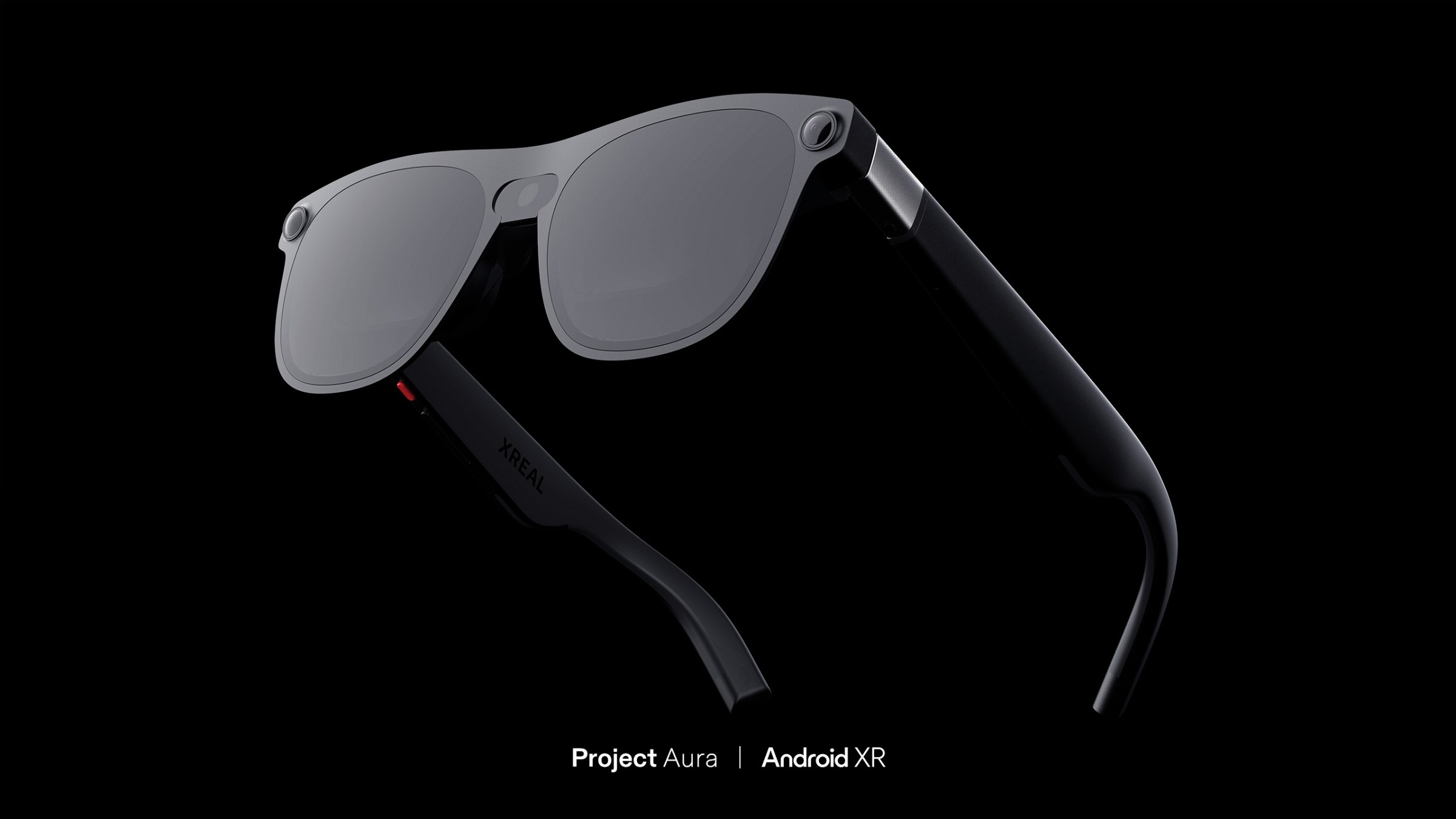 Render of what looks like a pair of regular sunglasses but with a camera in the hinge. The words Project Aura and Android XR at at the bottom.