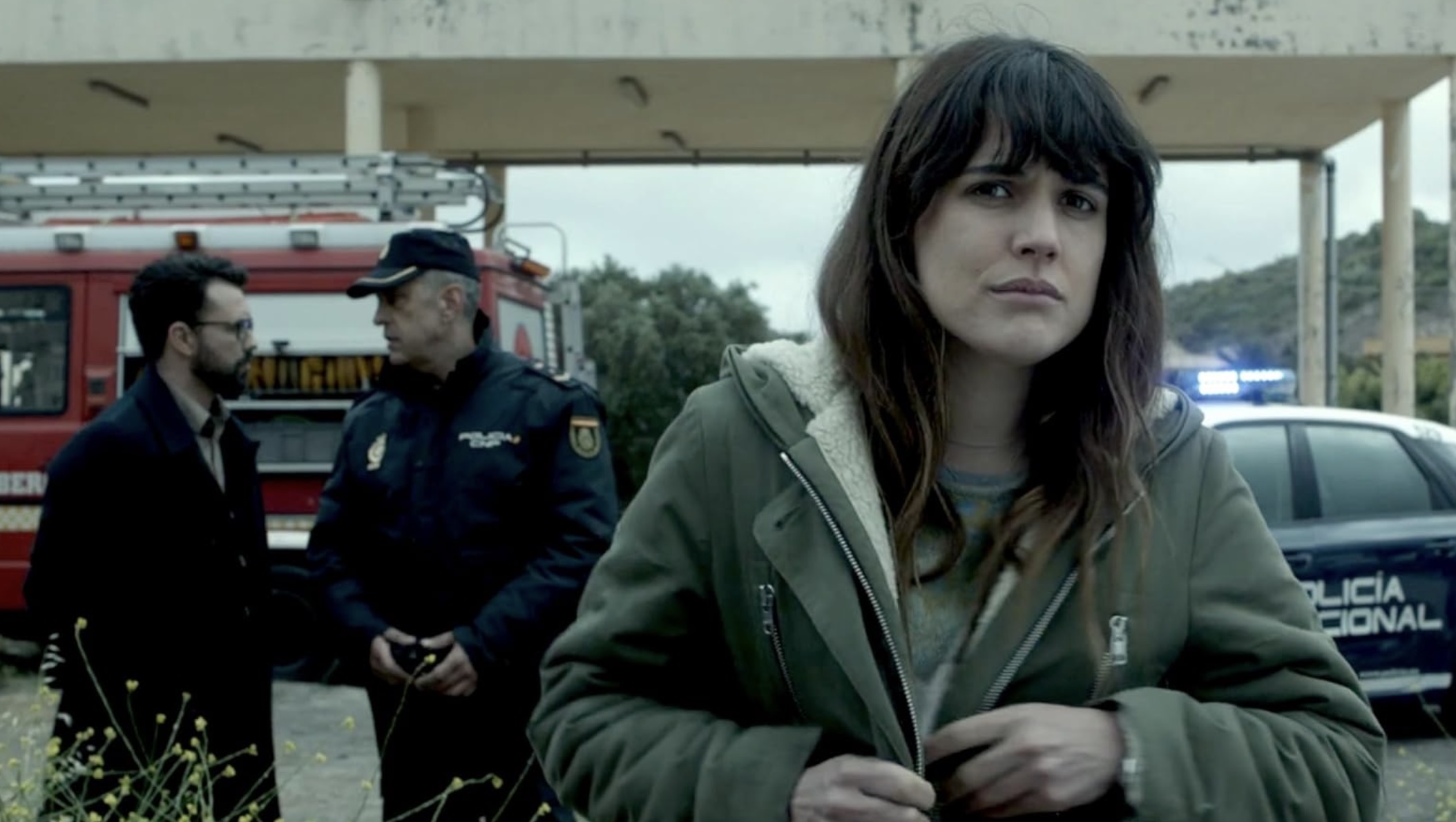A woman holds her coat as she stands in front of police in Mirage.