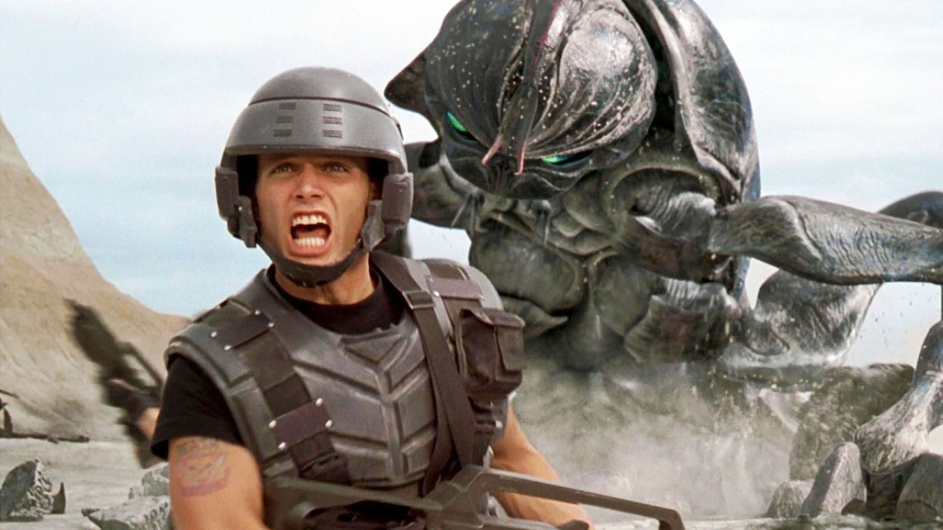 Casper Van Dien shouts orders on the battlefield as an alien bug advances in Starship Troopers.