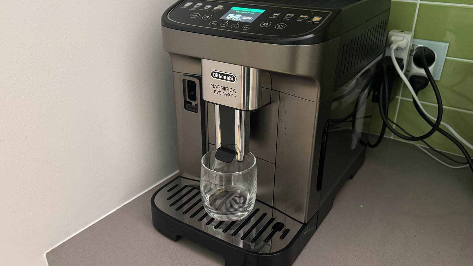A small glass under the spouts of the .De'Longhi Magnifica Evo Next coffee machine