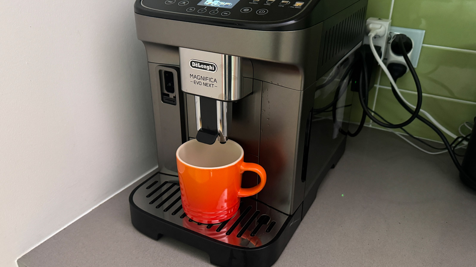 A large mug under the nozzles of the De'Longhi Magnifica Evo Next coffee machine.