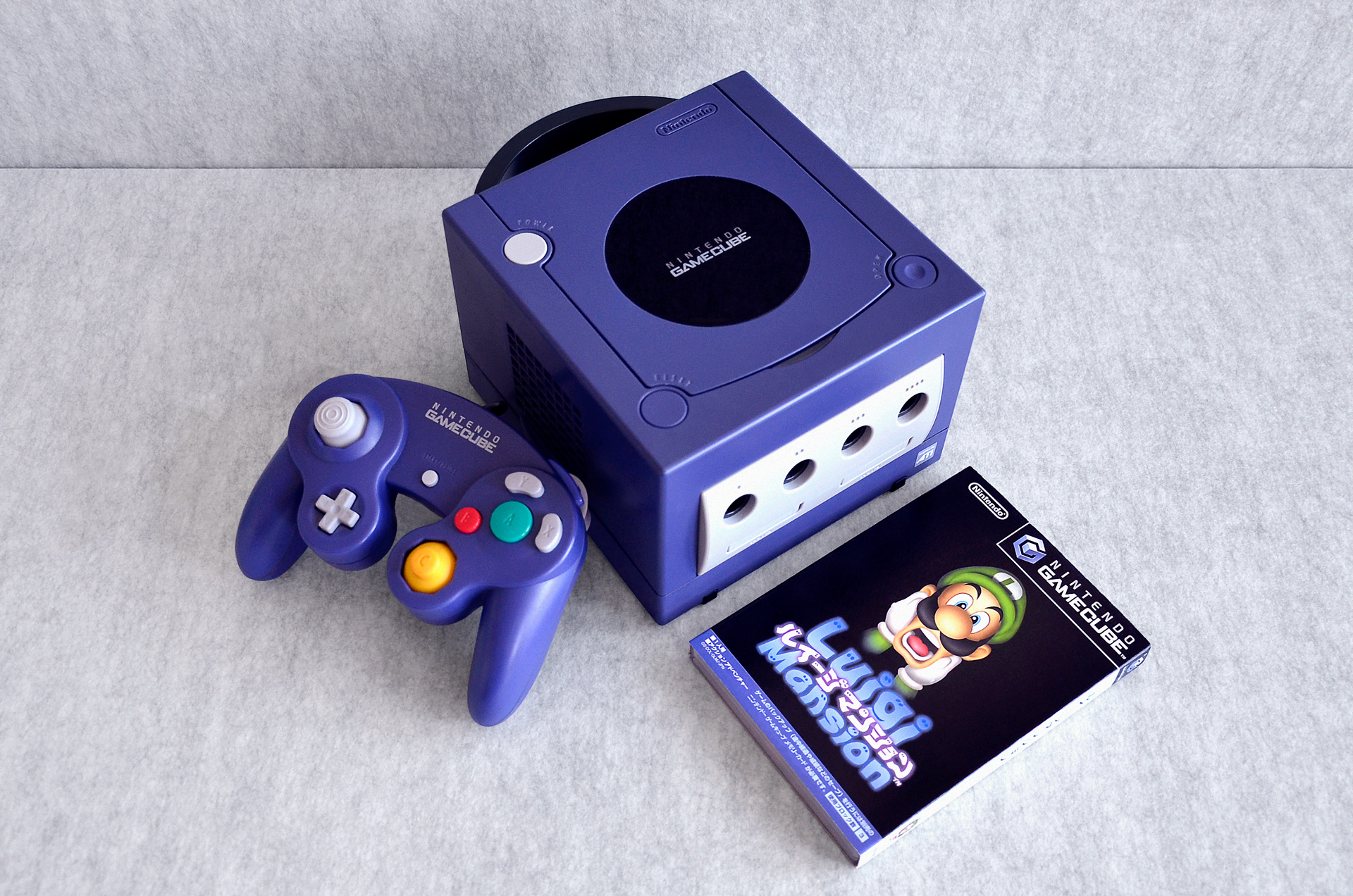 A Nintendo GameCube sits on a table with Luigi's Mansion.