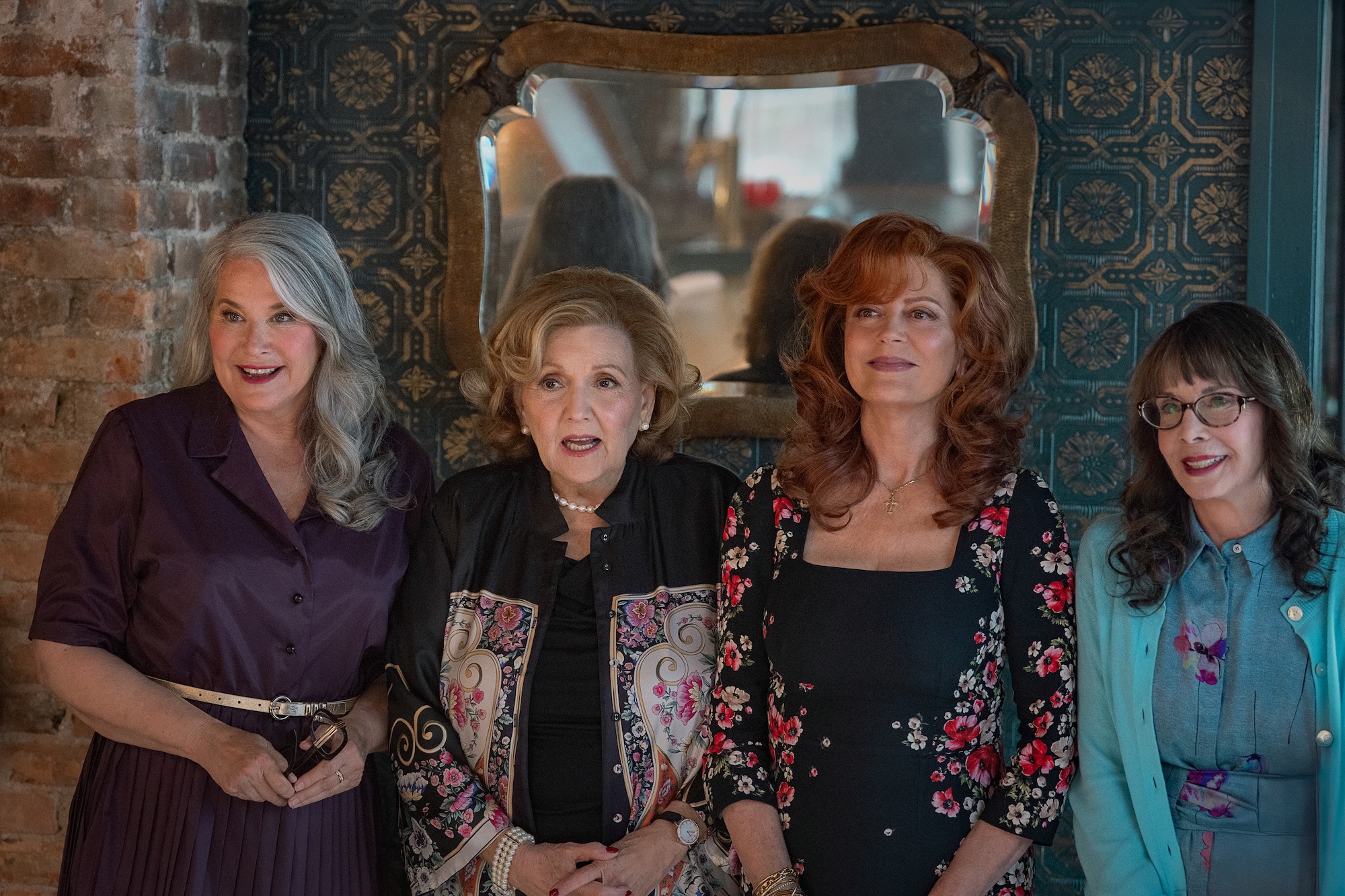 Four women look amused and stand in a line in Nonnas.