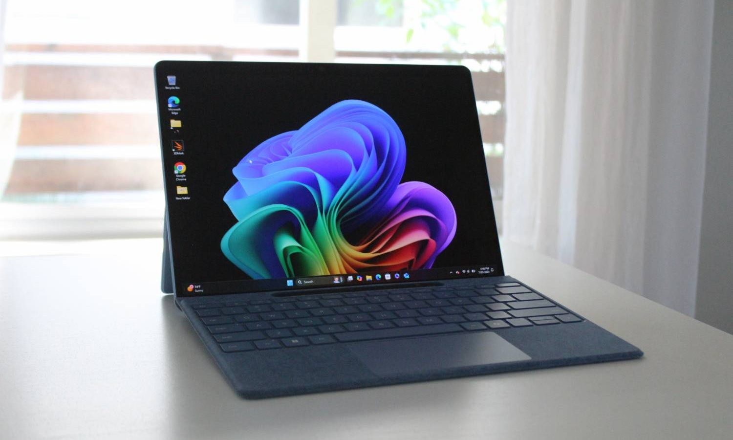 The Surface Pro 11 on a white table in front of a window.