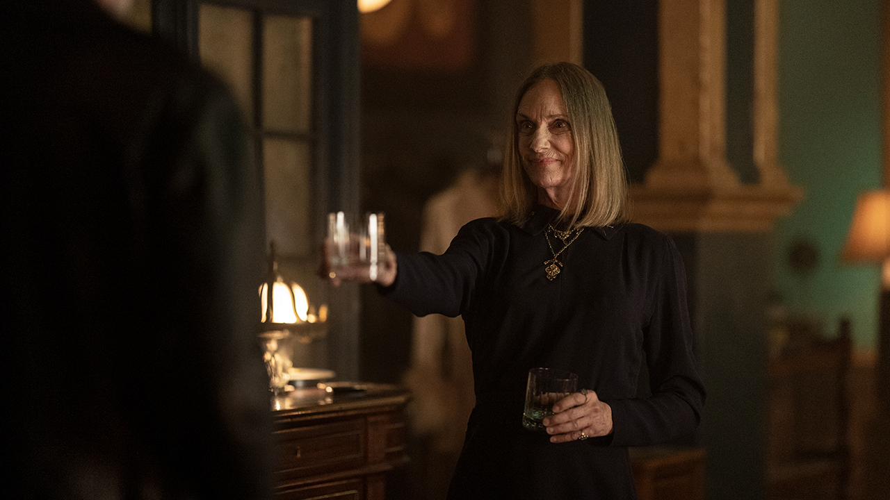 The Dama holding out a glass to Negan and smiling in The Walking Dead: Dead City.