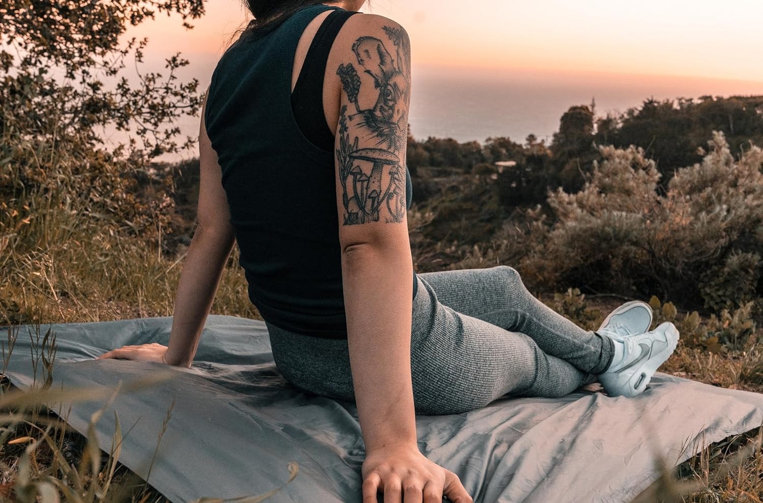 Person sitting on silvery fold-out blanket in k