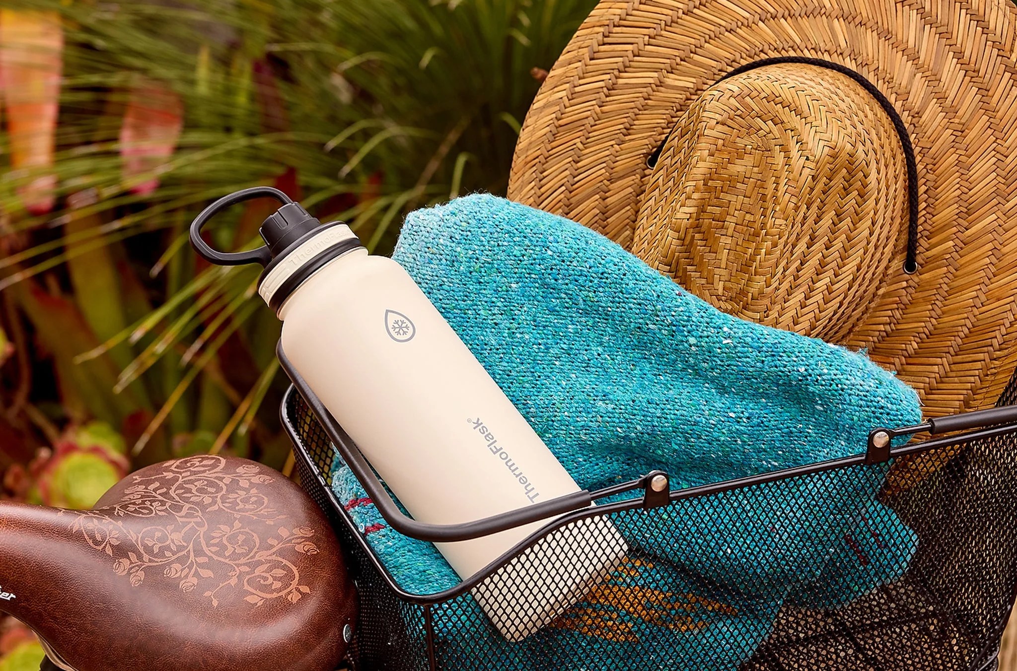 ThermoFlask thermos in a metal basket with a towel and sunhat