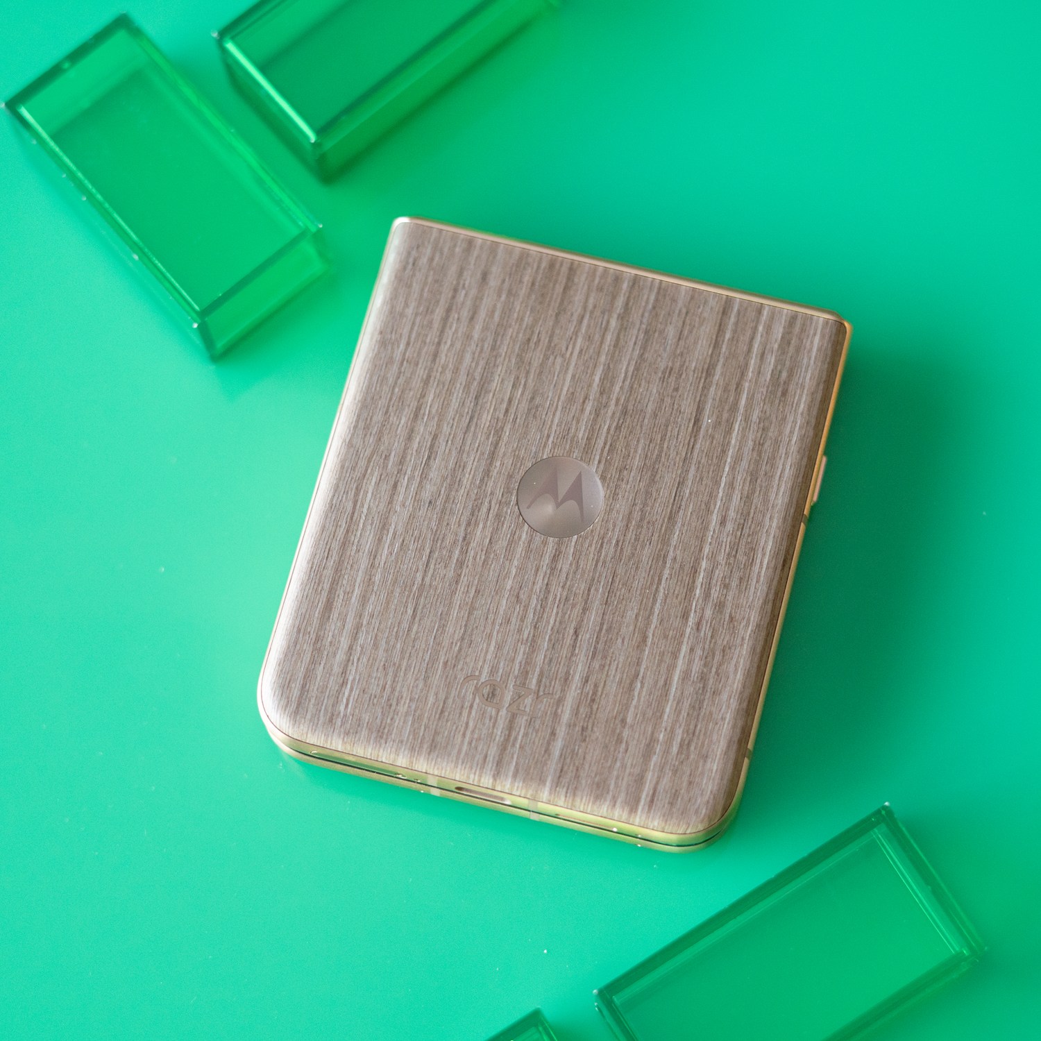 Motorola Razr Ultra on a green background showing wooden back panel