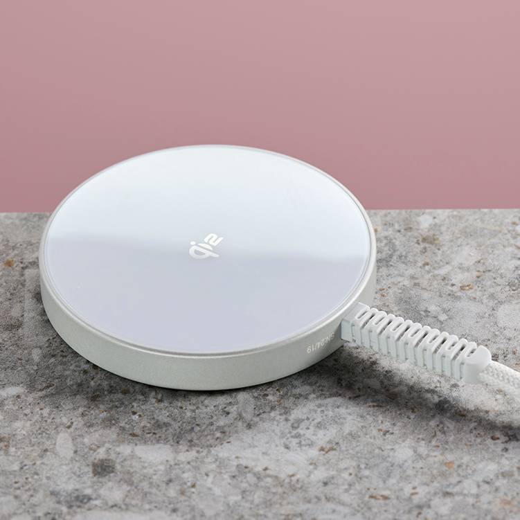 The ESR Qi2 Mini Wireless Charger against a pink background.