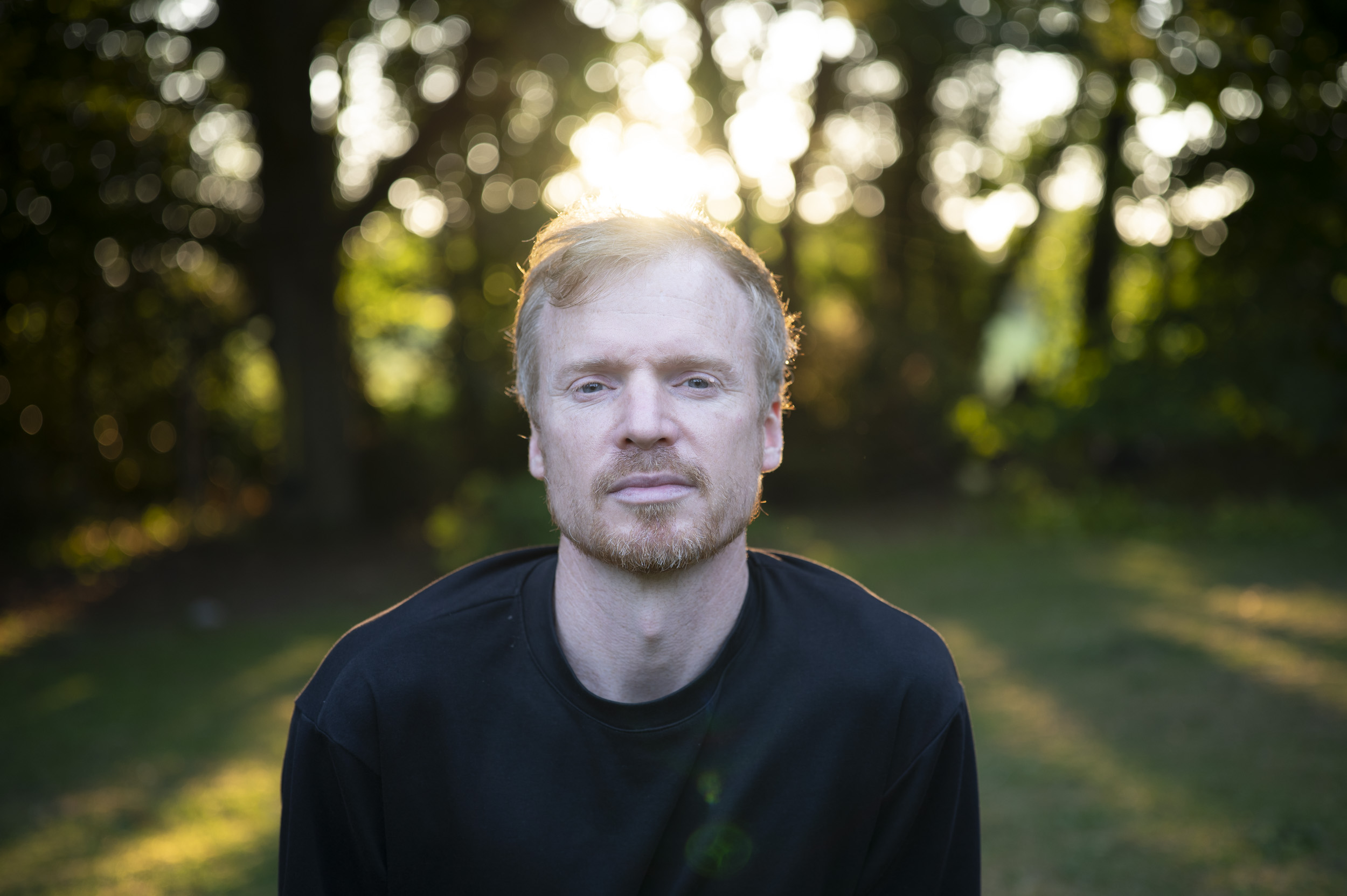 Portrait of a man during golden hour with dappled light through trees, taken with the Viltrox AF 50mm F2 Air lens