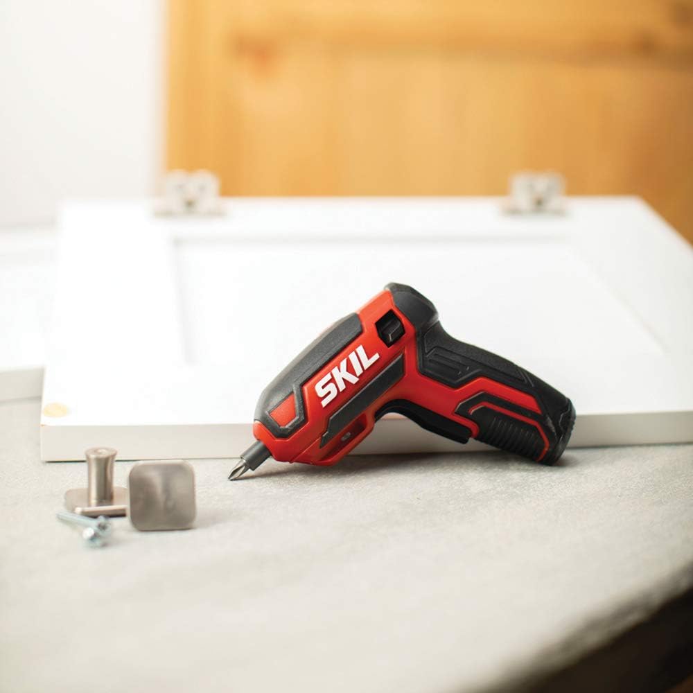 Electric screwdriver with hand grip on top of table.