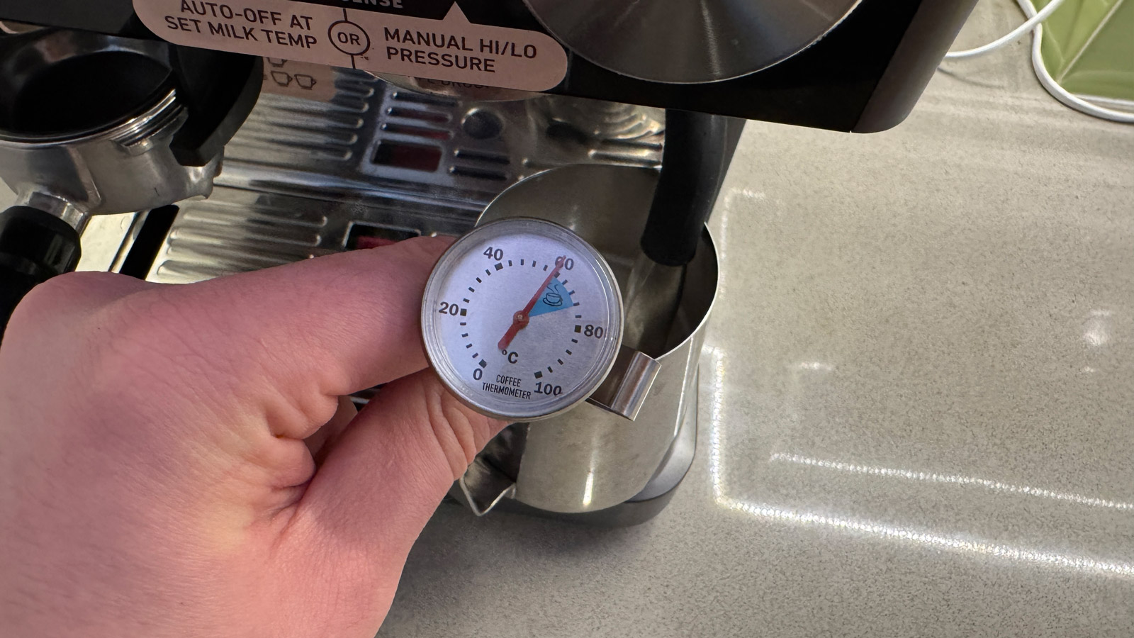 A milk thermometer being used in some milk