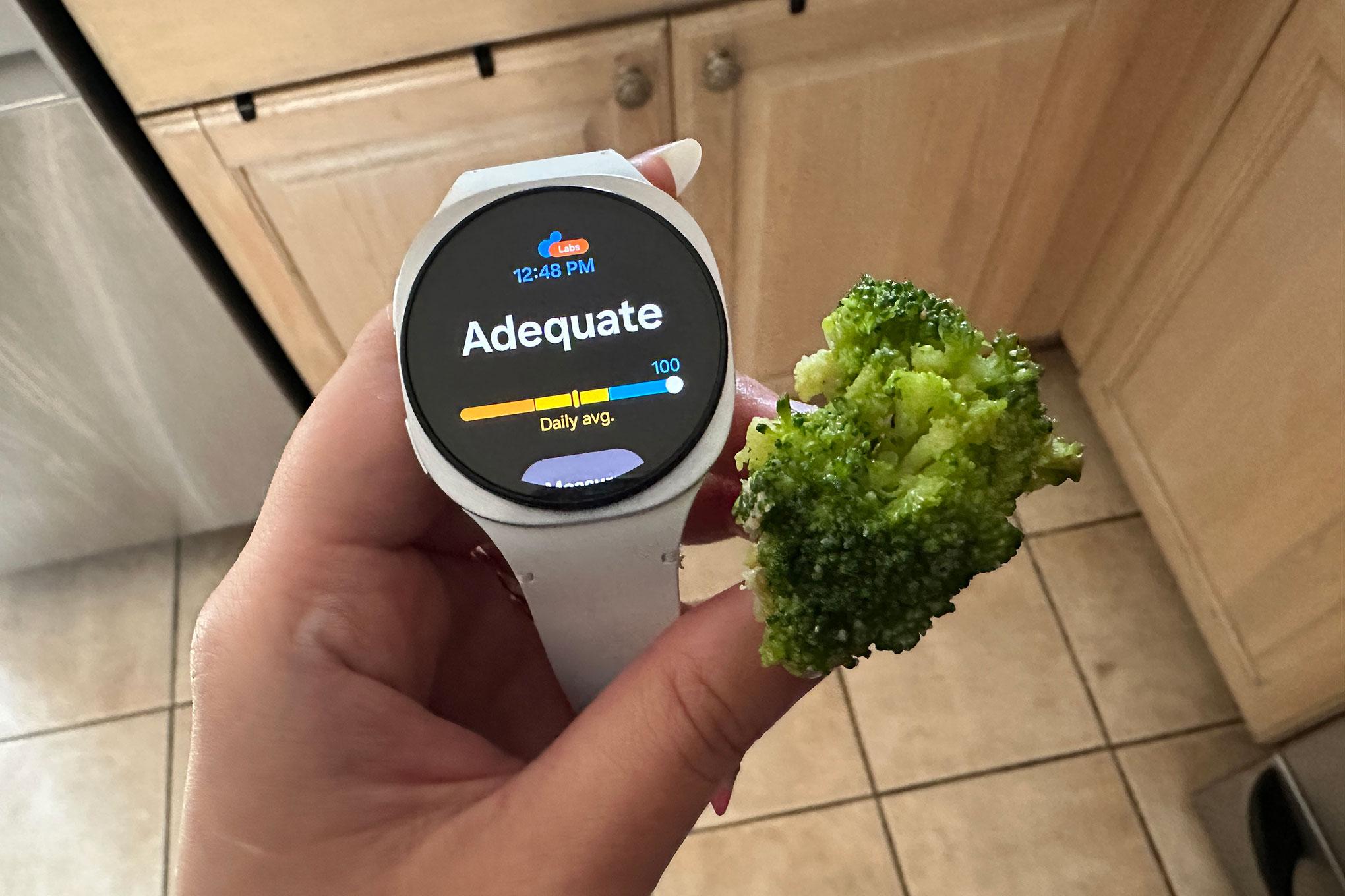 the samsung Galaxy Watch 8 with a piece of broccoli showing a score of 100