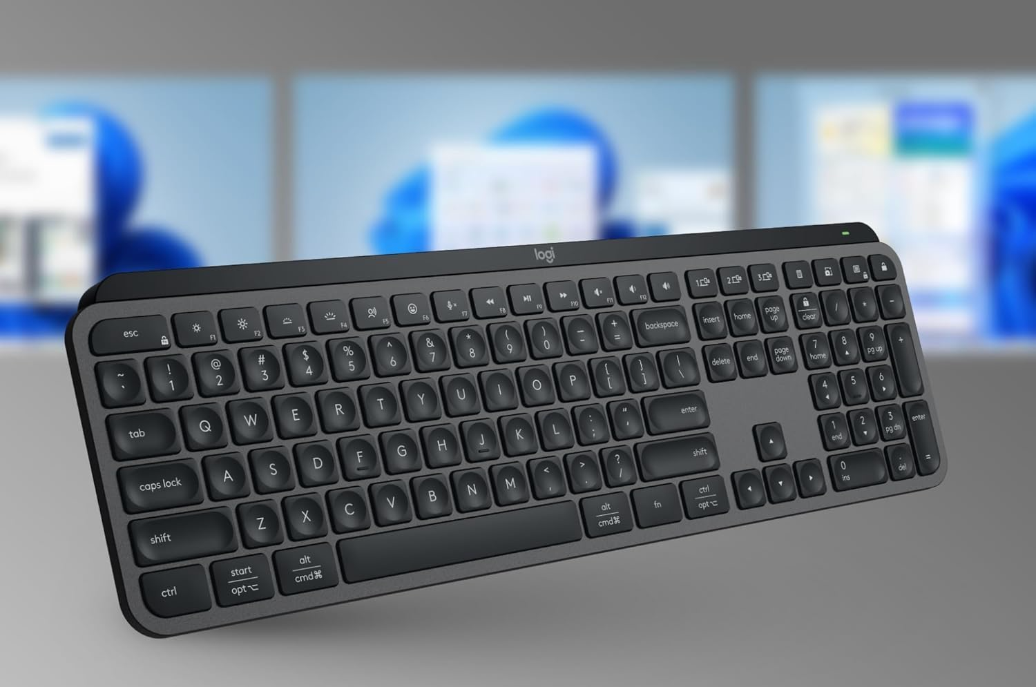 Keyboard in front of three monitors