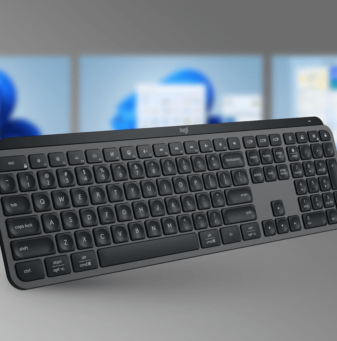 Keyboard in front of three monitors