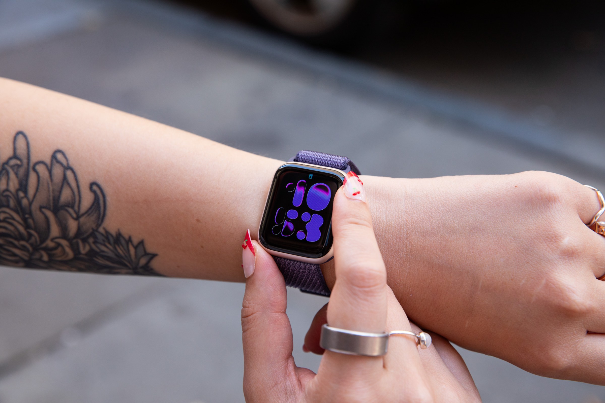 Person looking at the Apple Watch SE 3 on a wrist showing an inactive always-on display that can still sho the time.