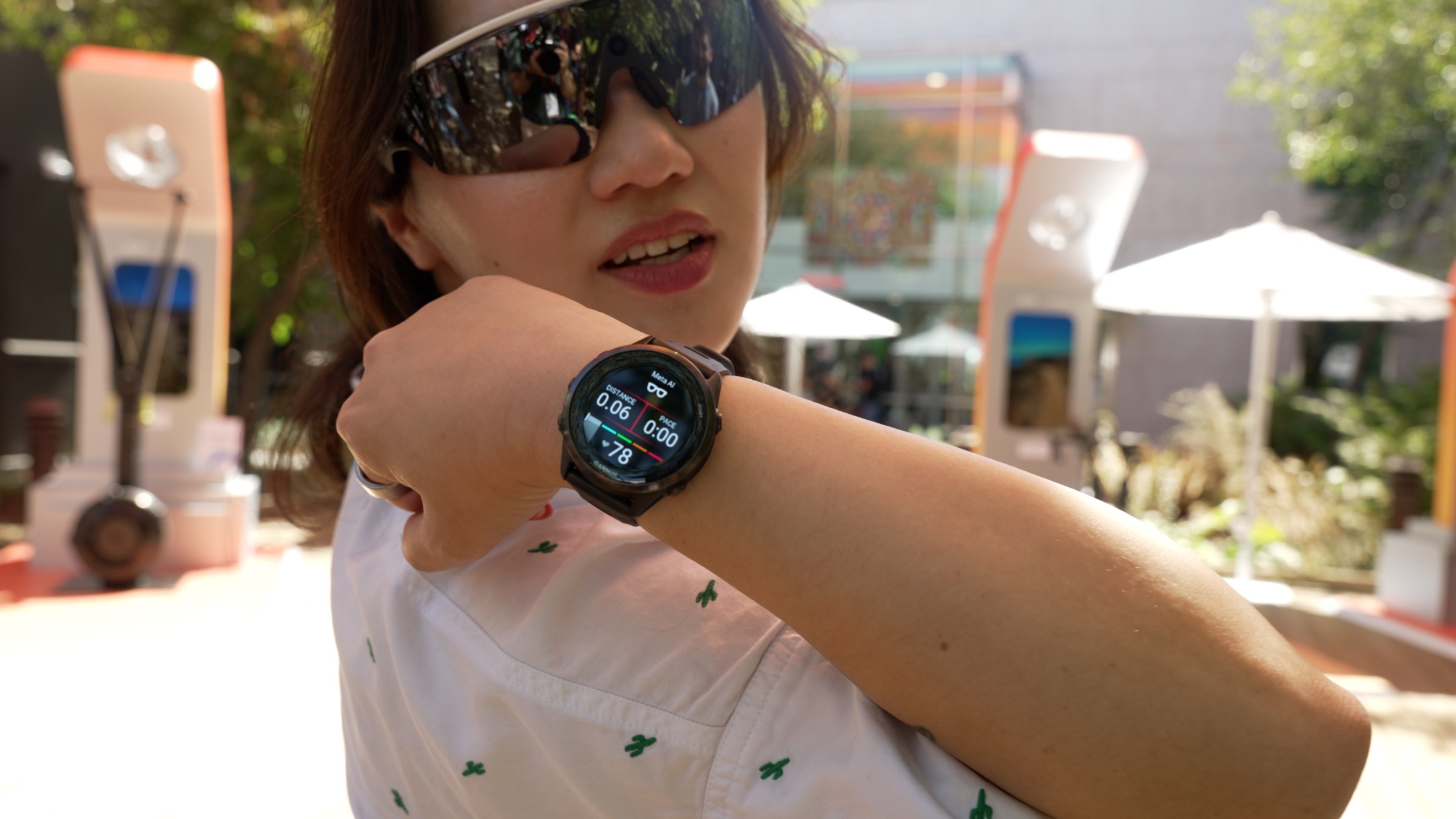 Senior Reviewer Victoria Song showing off a Garmin watch with the Meta AI integration while wearing Oakley Meta Vanguard glasses in a sunny area