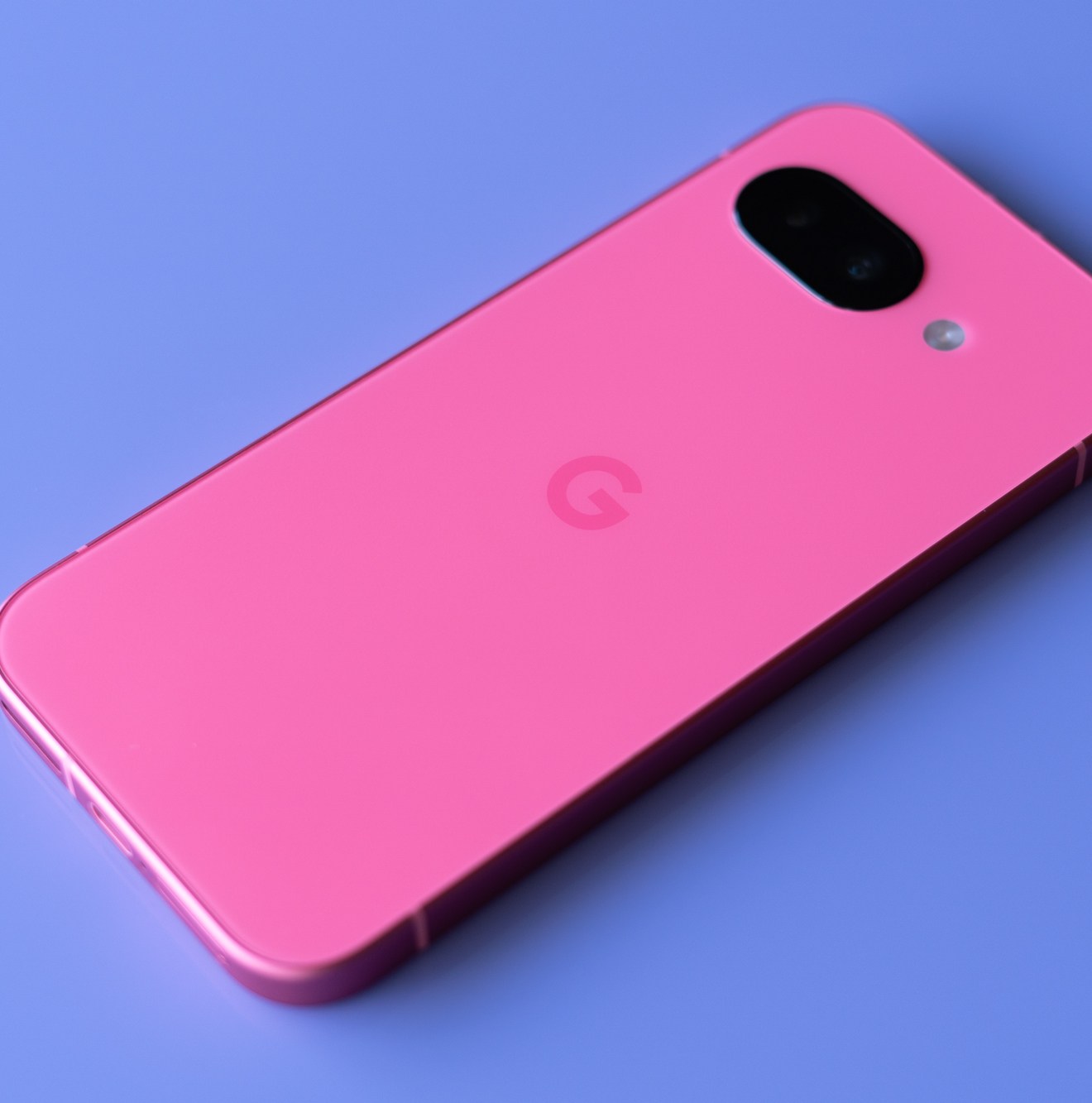 Google Pixel 9A in peony pink on a purple background.