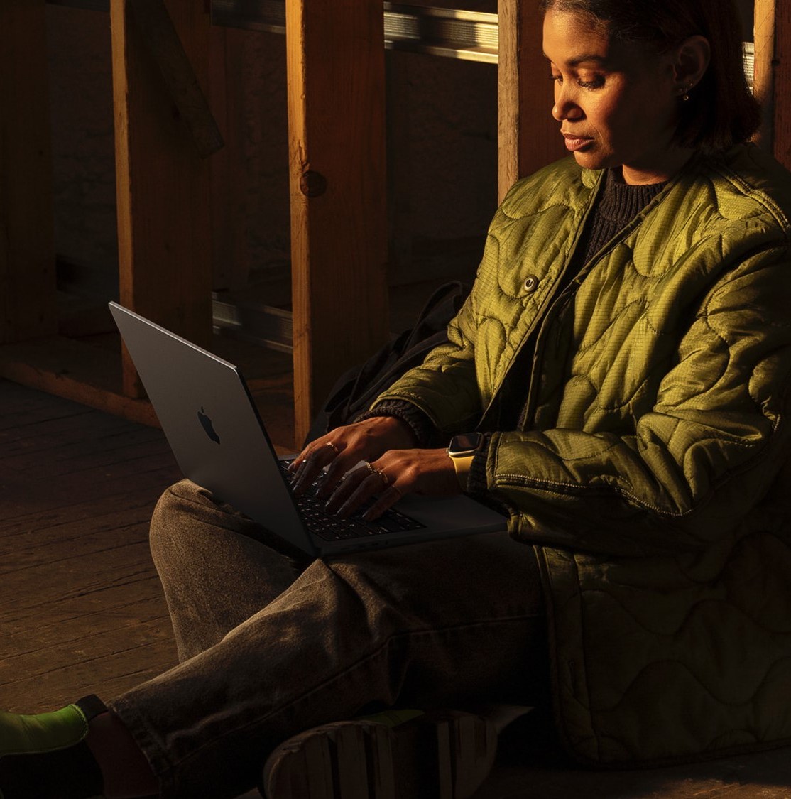 Someone sitting on ground using MacBook Pro
