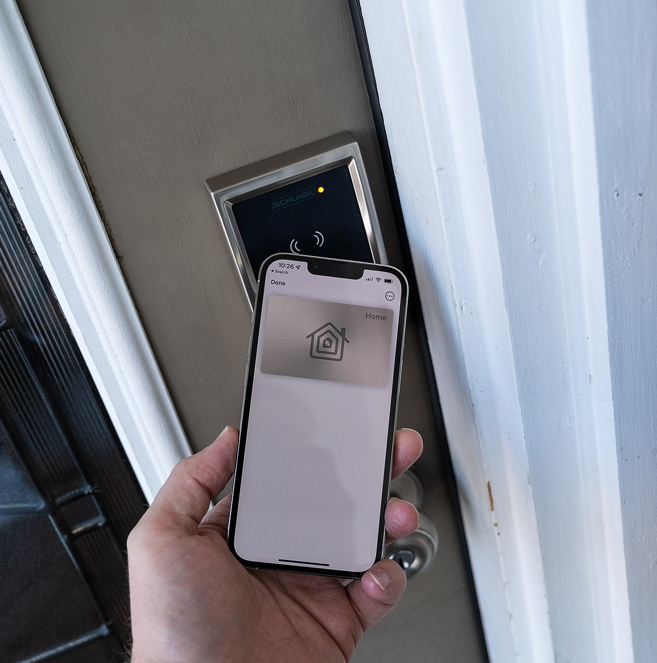 An iPhone being used to unlock the Schlage Encode Plus smart lock.