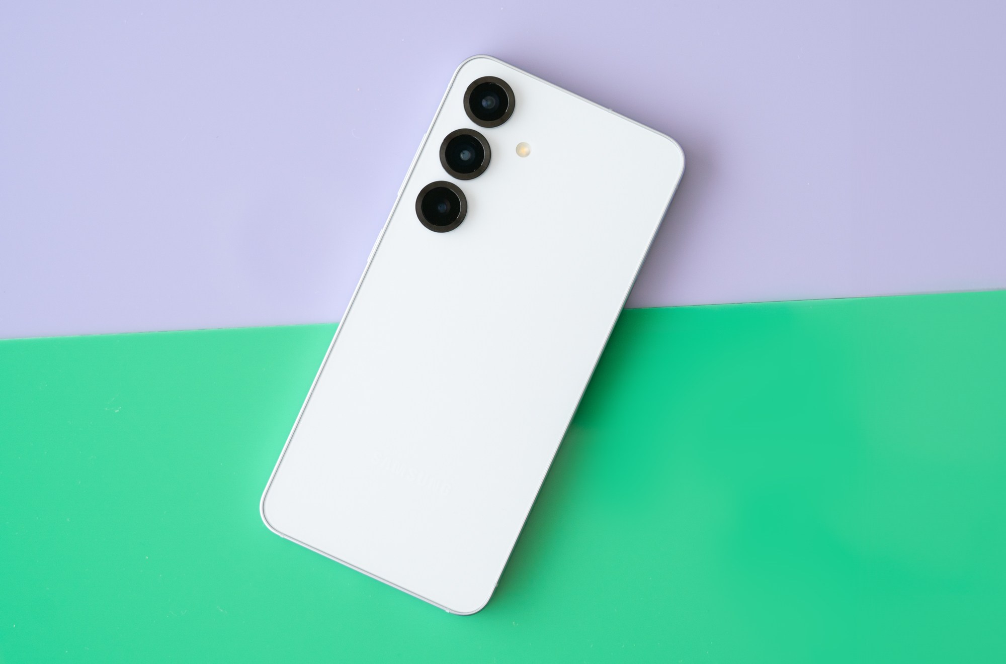 Samsung Galaxy S25 on a green and purple background.