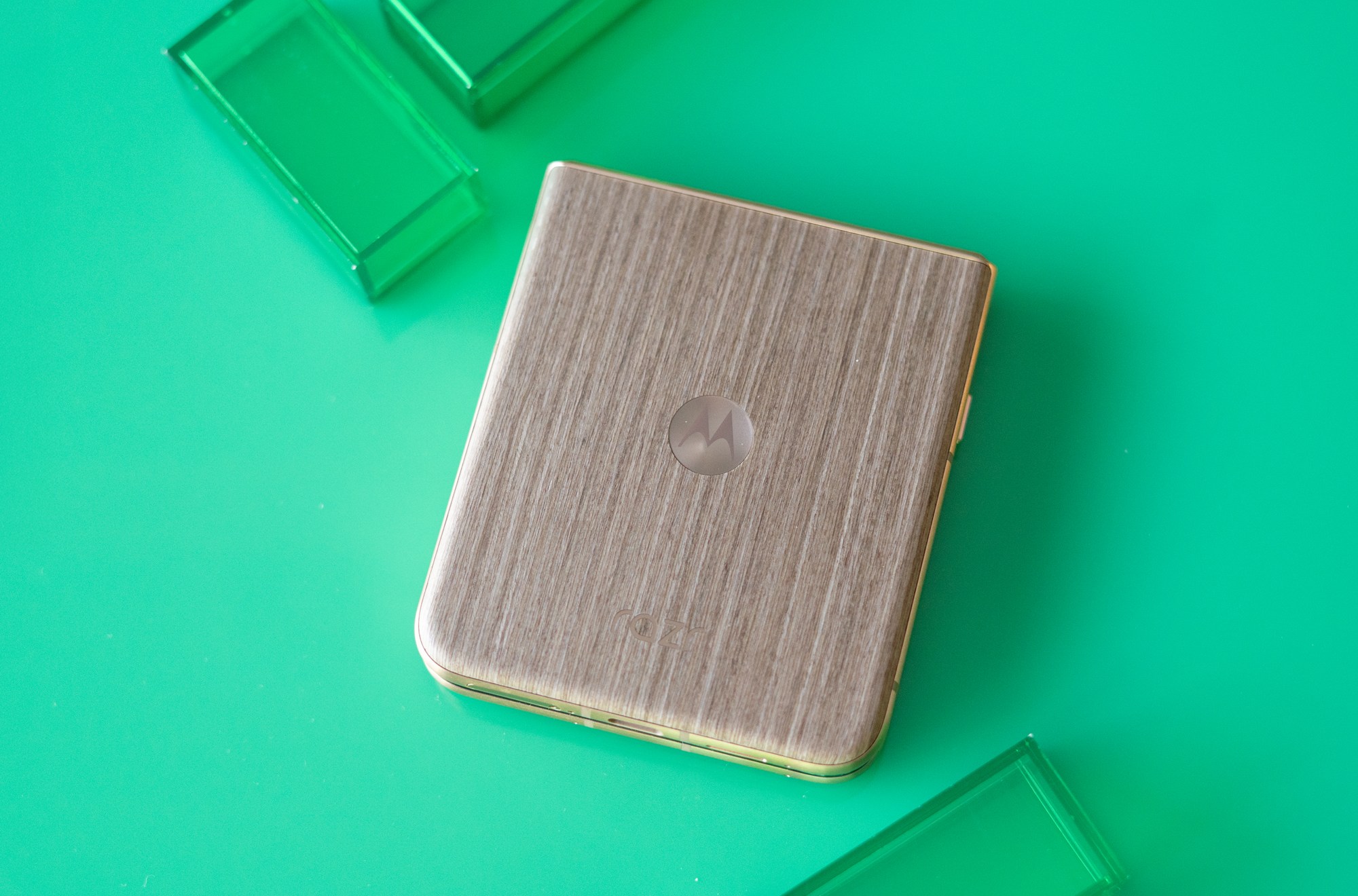 Motorola Razr Ultra on a green background showing wooden back panel