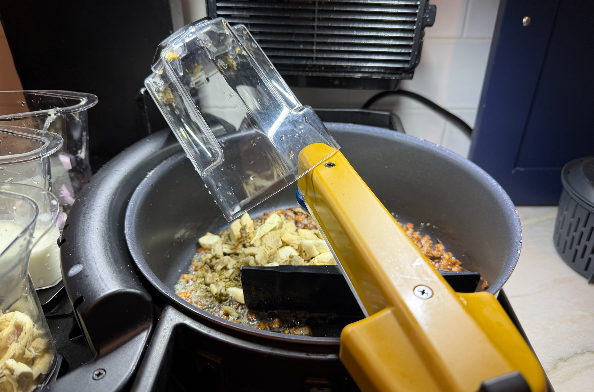 Posha cooking robot with pot full of food coking.