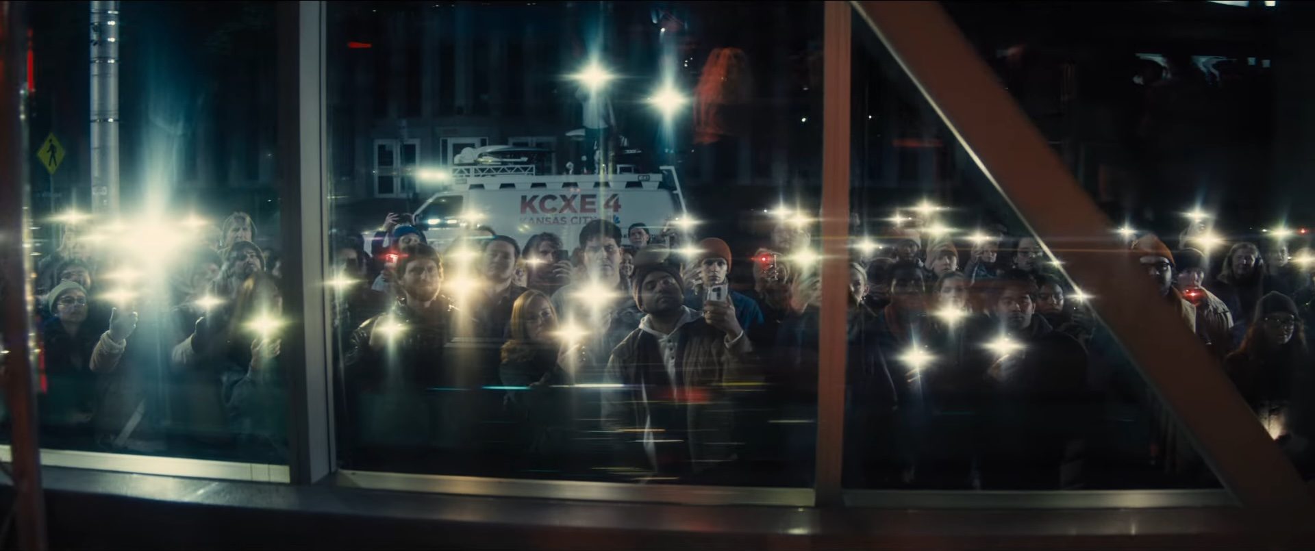 A crowd of people shining lights from their smartphones in the 2026 sci-fi film Disclosure Day.