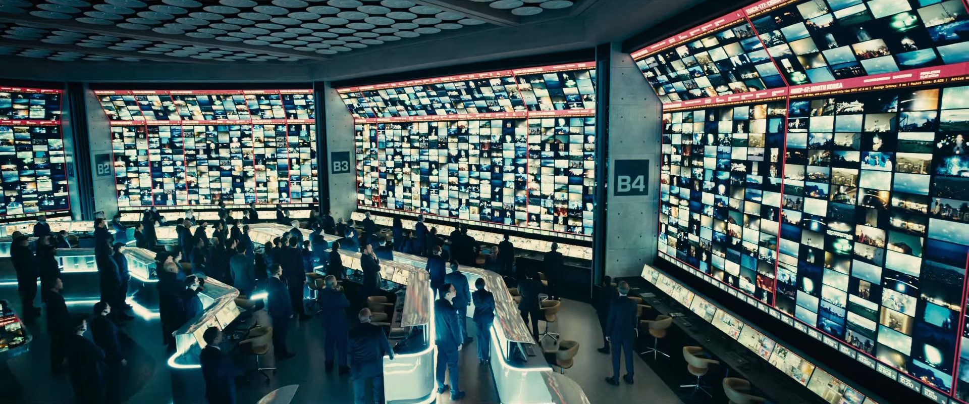 A group of people watching giant screens in a high-tech facility in the 2026 sci-fi film Disclosure Day.