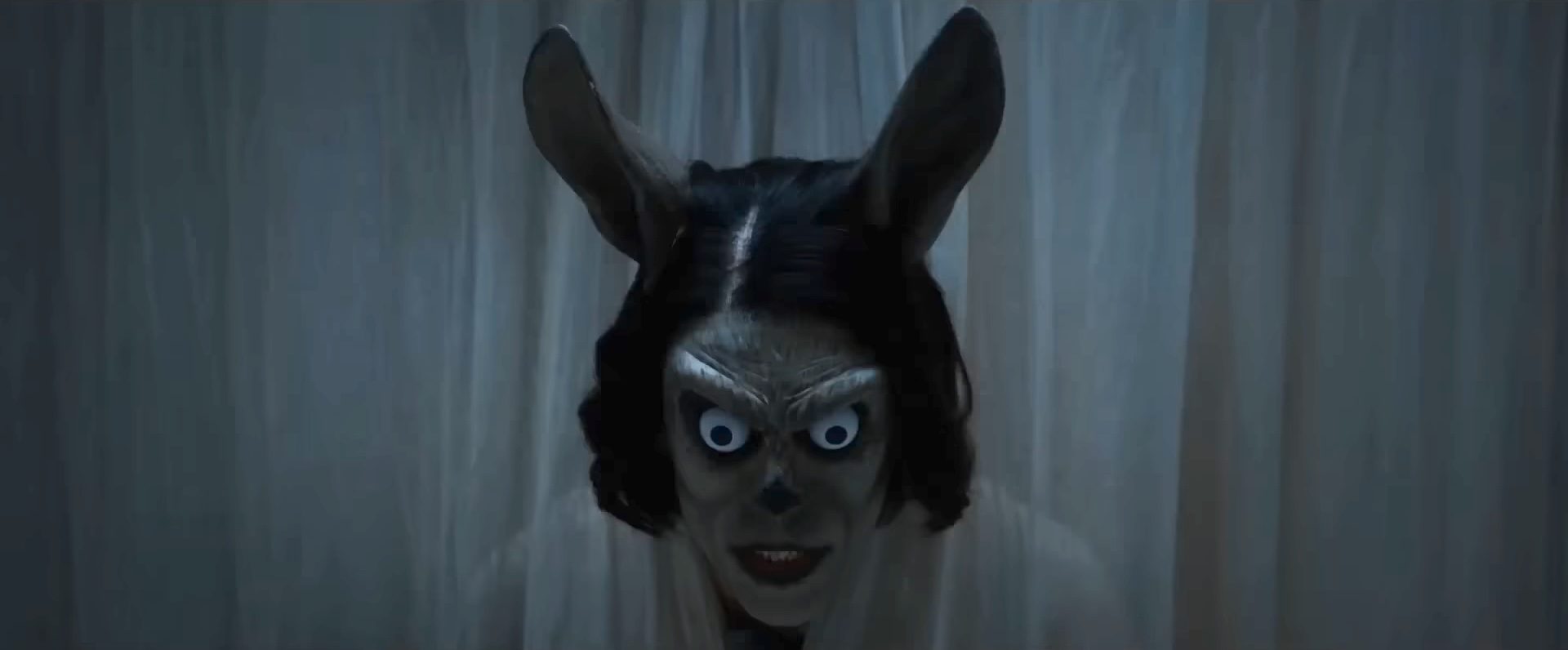 A scary woman with big eyes and ears in the horror film Hokum.