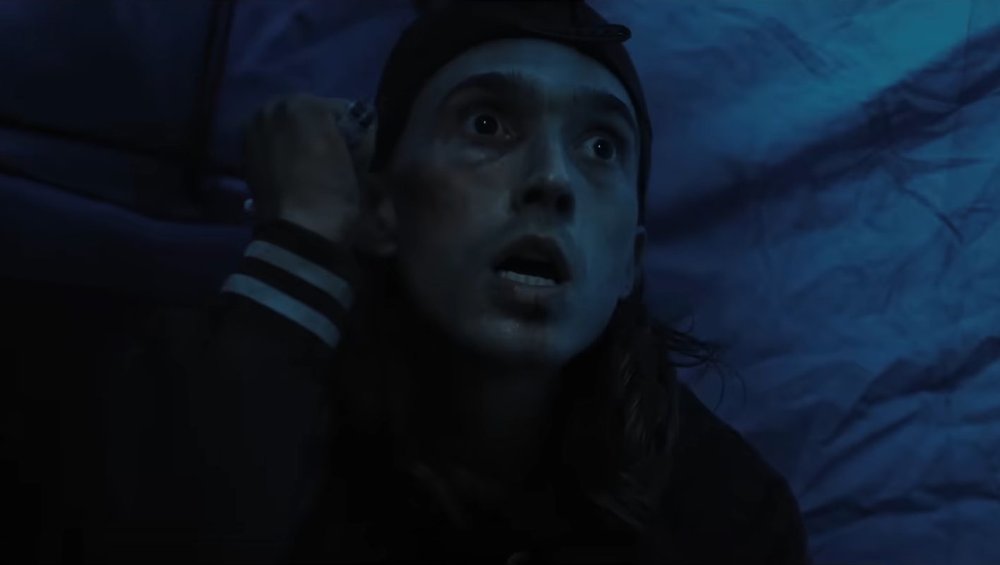 Austin Abrams terrified in a tent in the horror movie Weapons.