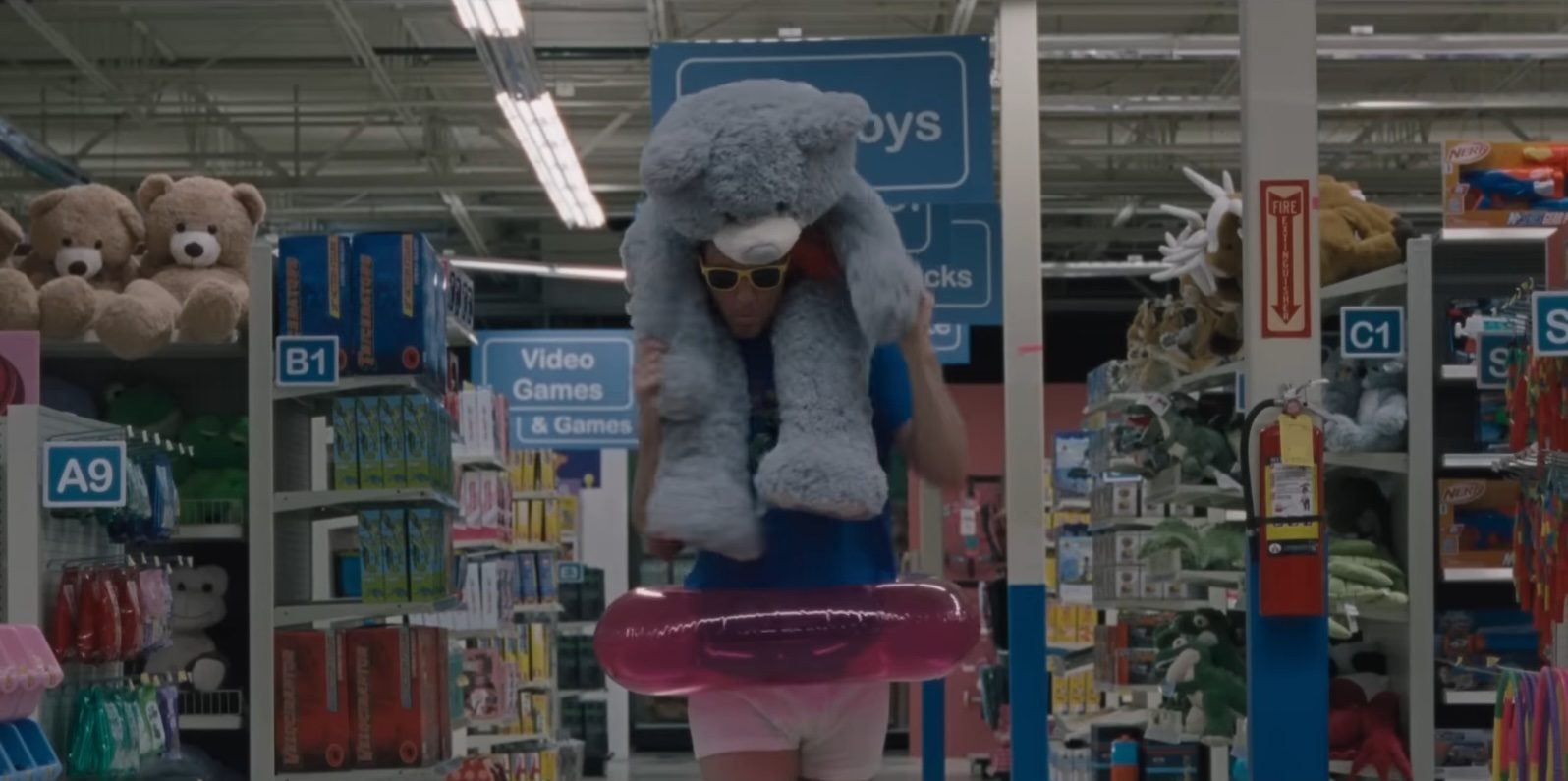 Channing Tatum carrying a giant plush bear and wearing an inner tube in Roofman