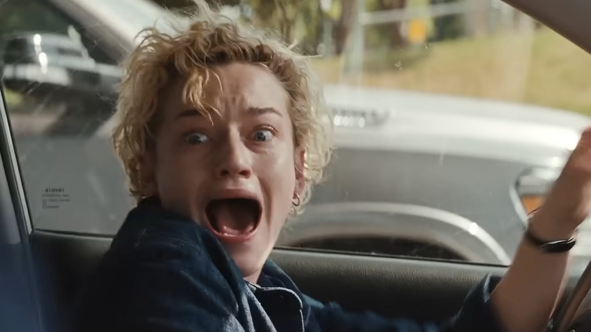 Julia Garner screaming in a car in the horror film Weapons.
