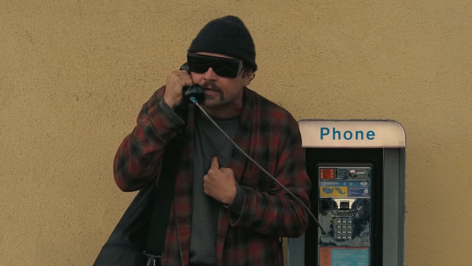 Leonardo DiCaprio talking on a payphone in One Battle After Another.